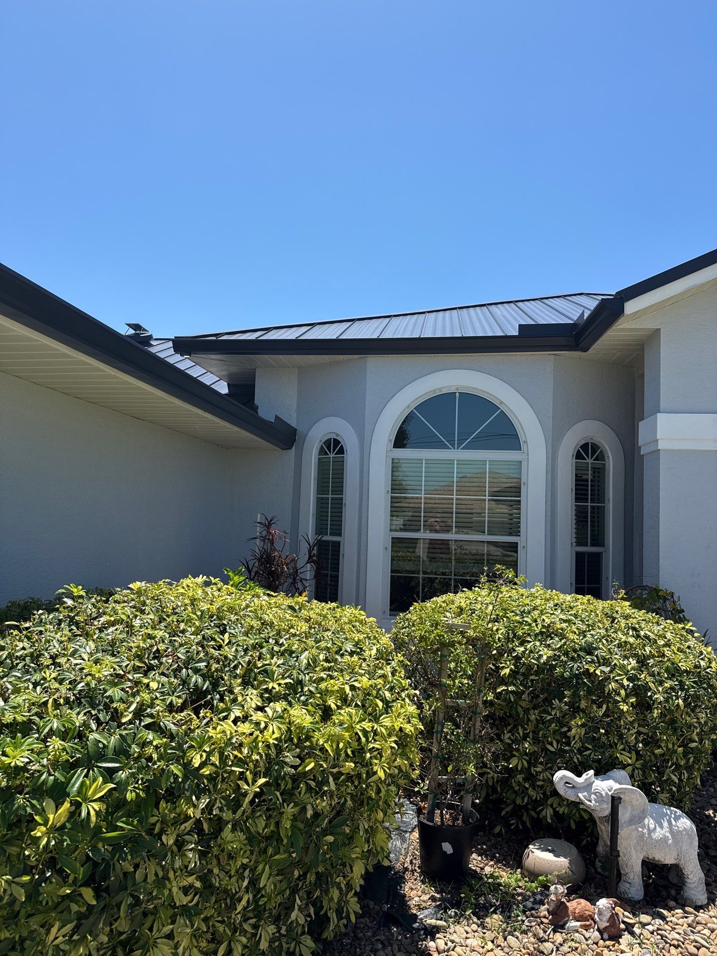 Black Seamless Gutters and White Downspouts in Cape Coral FL by Gutter Professors