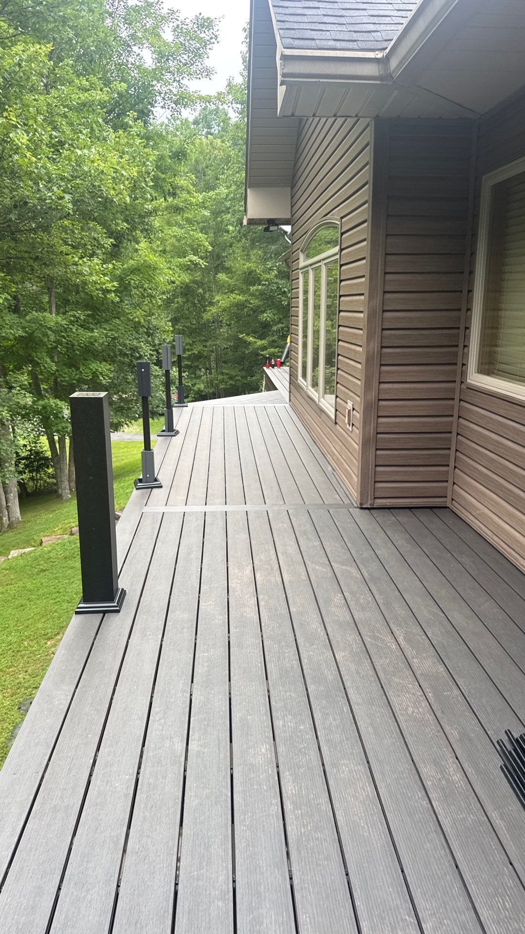 Custom Composite Deck Construction with Stone Pillars in Fayetteville by Walnut Hollow Decks & Outdoor Living