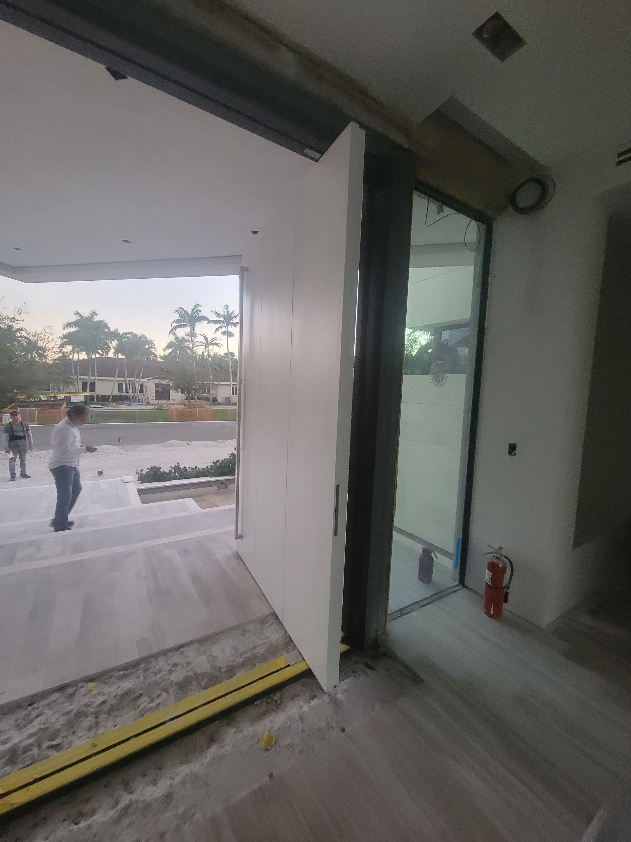 Custom Material Pivot Door installation by Impact Precious Wood Inc.