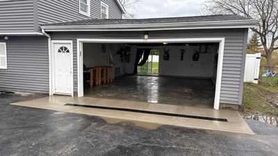 Concrete garage floor replacement with a broom finished apron and drain