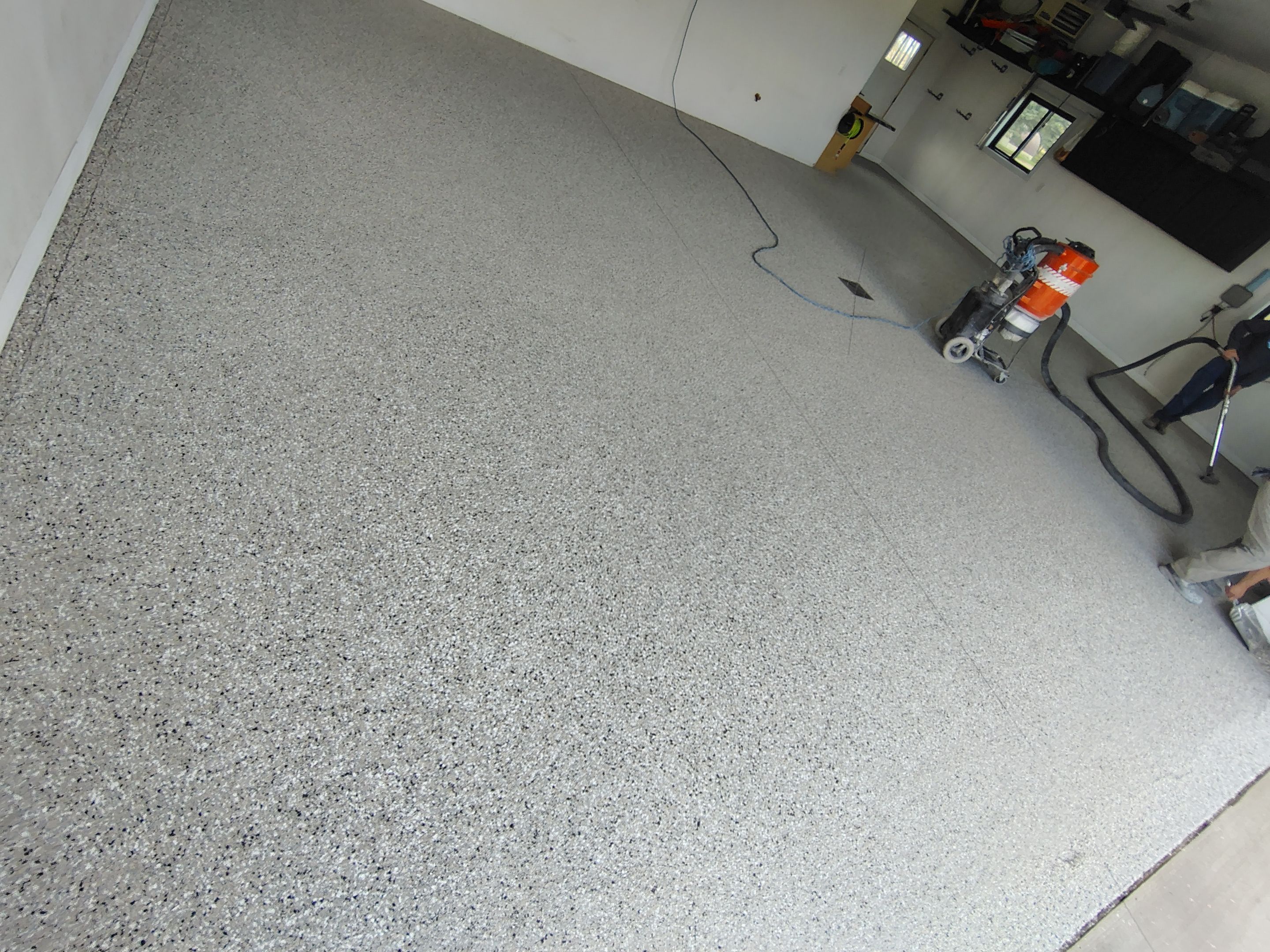 Speckled Polyaspartic Garage Floor Coating Installation in Dell Rapids by Select Painting, Coatings & Garage Cabinets