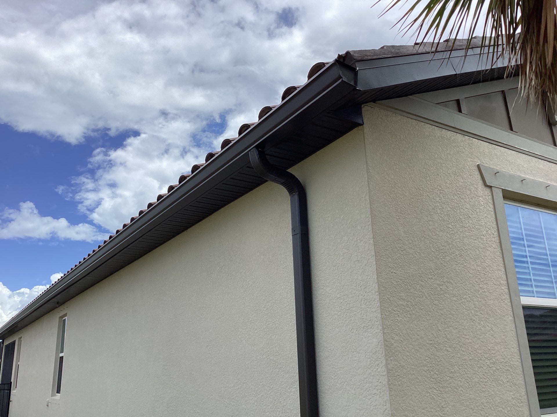 Musket brown seamless gutters with splash guards, new downspouts, and extensions in Bradenton, FL by Gutter Professors
