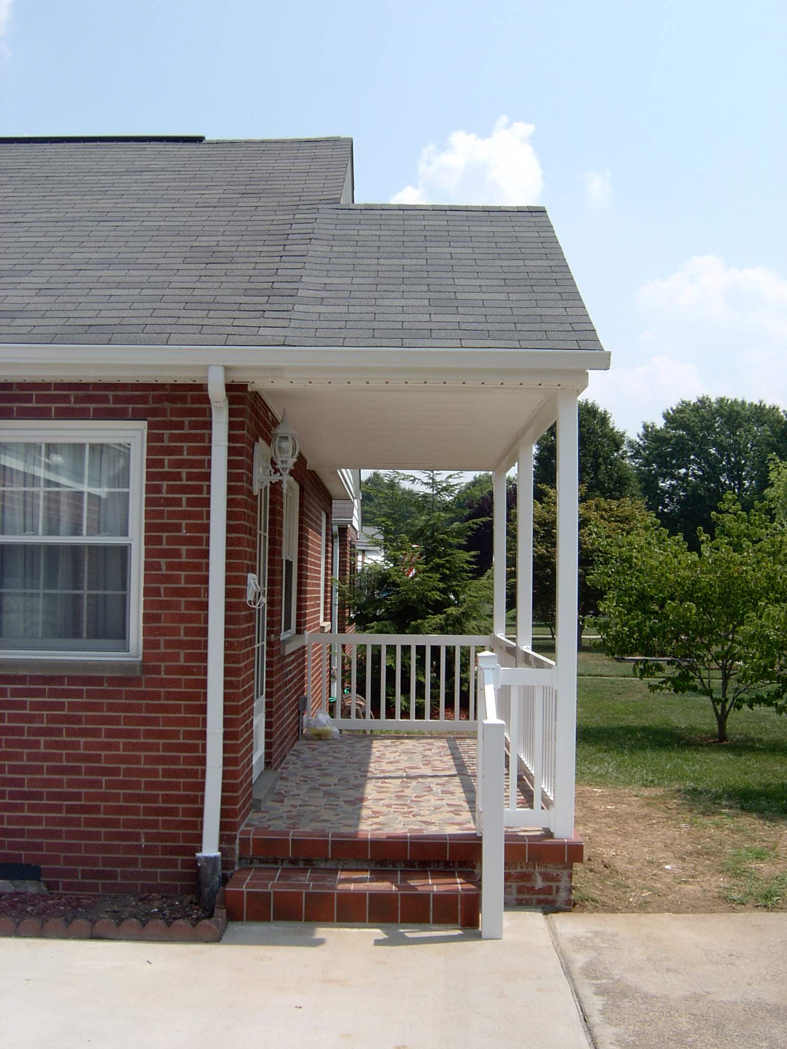 New front porch build, with tile floor and vinyl railing. by Secure Construction Company Inc