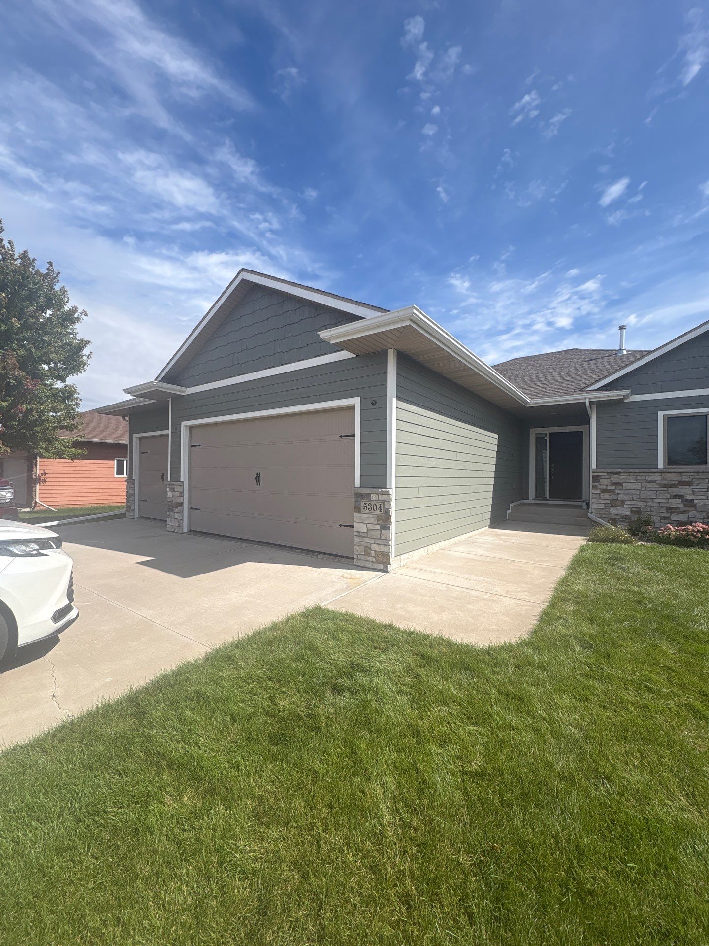 Full Exterior Home Painting on Blue Lap Siding in Sioux Falls by Select Painting, Coatings & Garage Cabinets