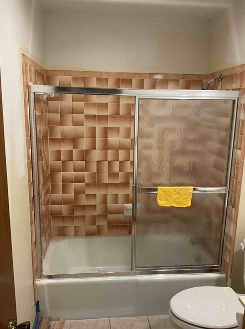 Bathtub, door, toilet, flooring, and countertop by The Shower Company