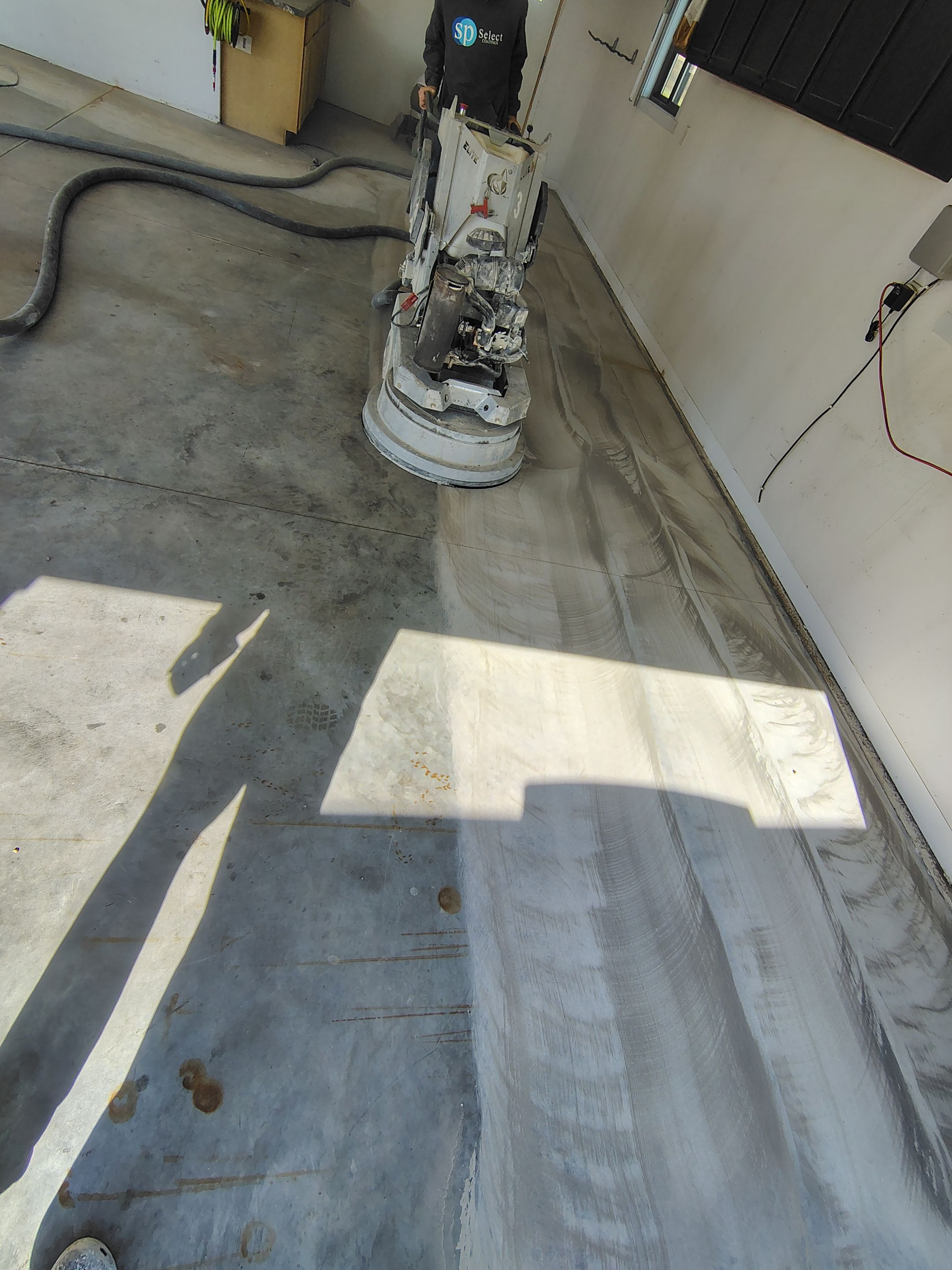 Speckled Polyaspartic Garage Floor Coating Installation in Dell Rapids by Select Painting, Coatings & Garage Cabinets