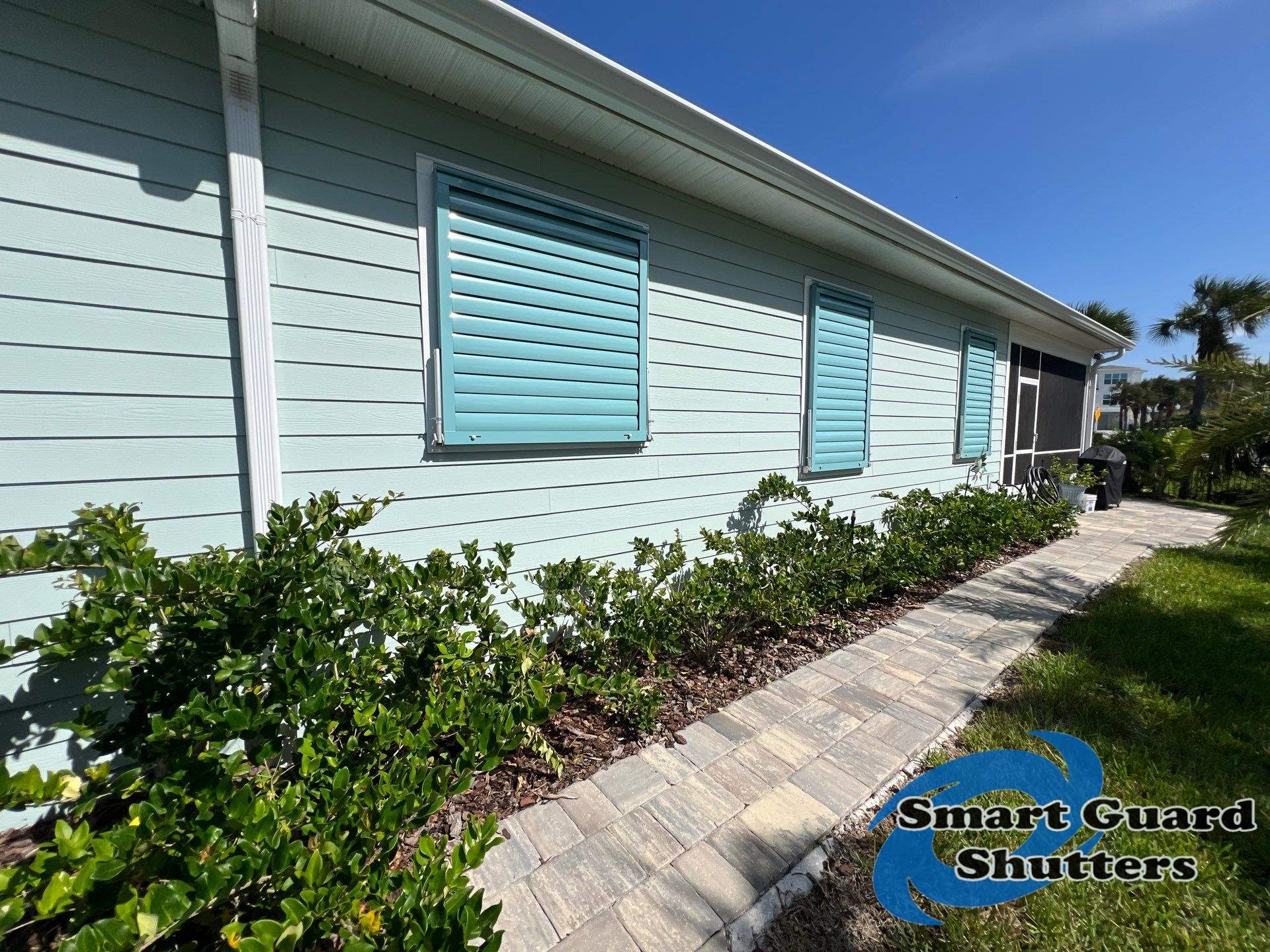 Impact Bahama Shutters in Pastel Turquoise by Smart Guard Shutters