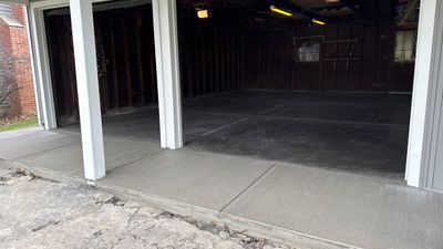 Concrete garage floor replacement with a broom finished apron and sidewalk