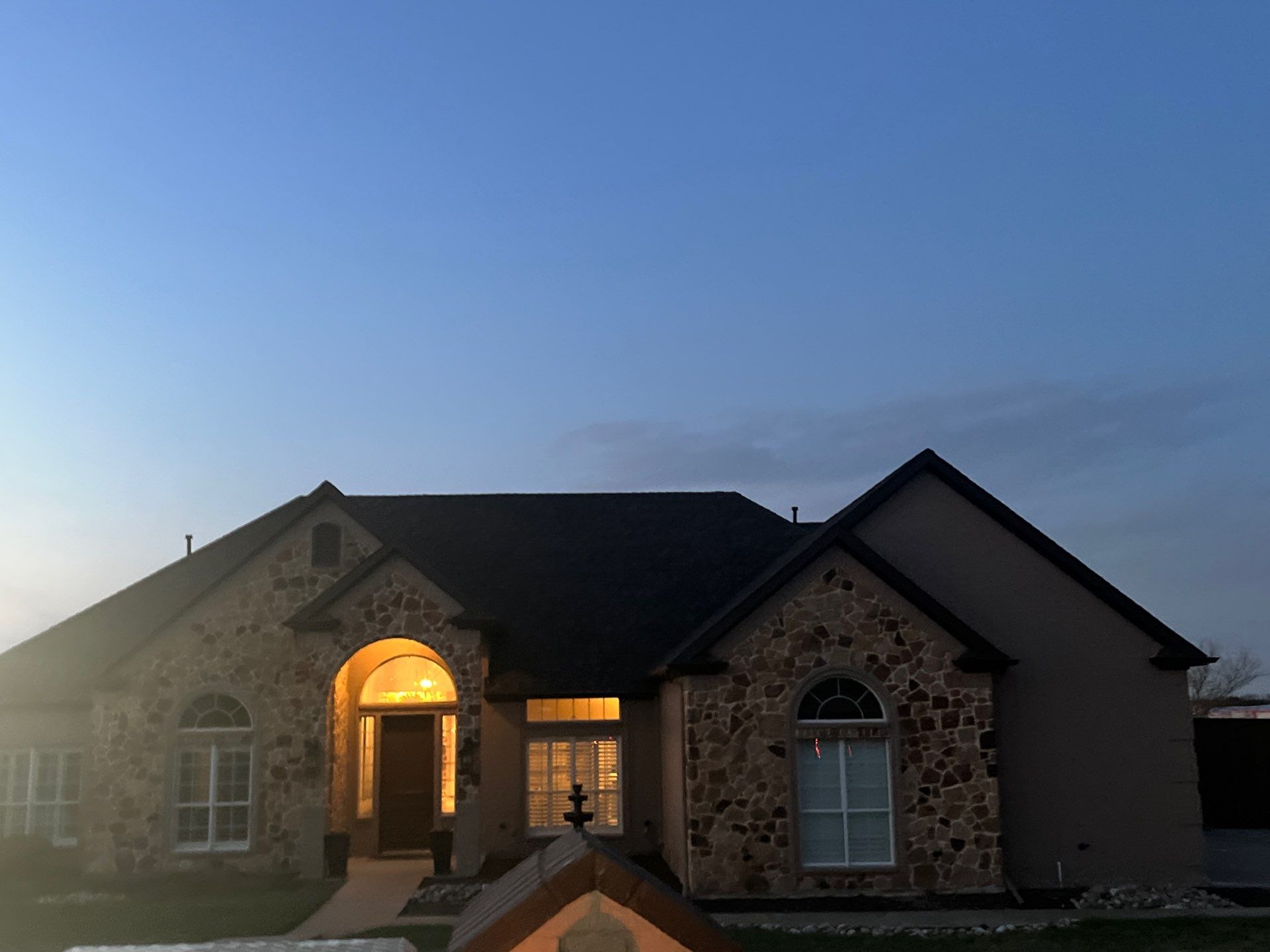Cream brick/mixed stone with IKO Shadow Brown by Tejas Roofworks + Restoration