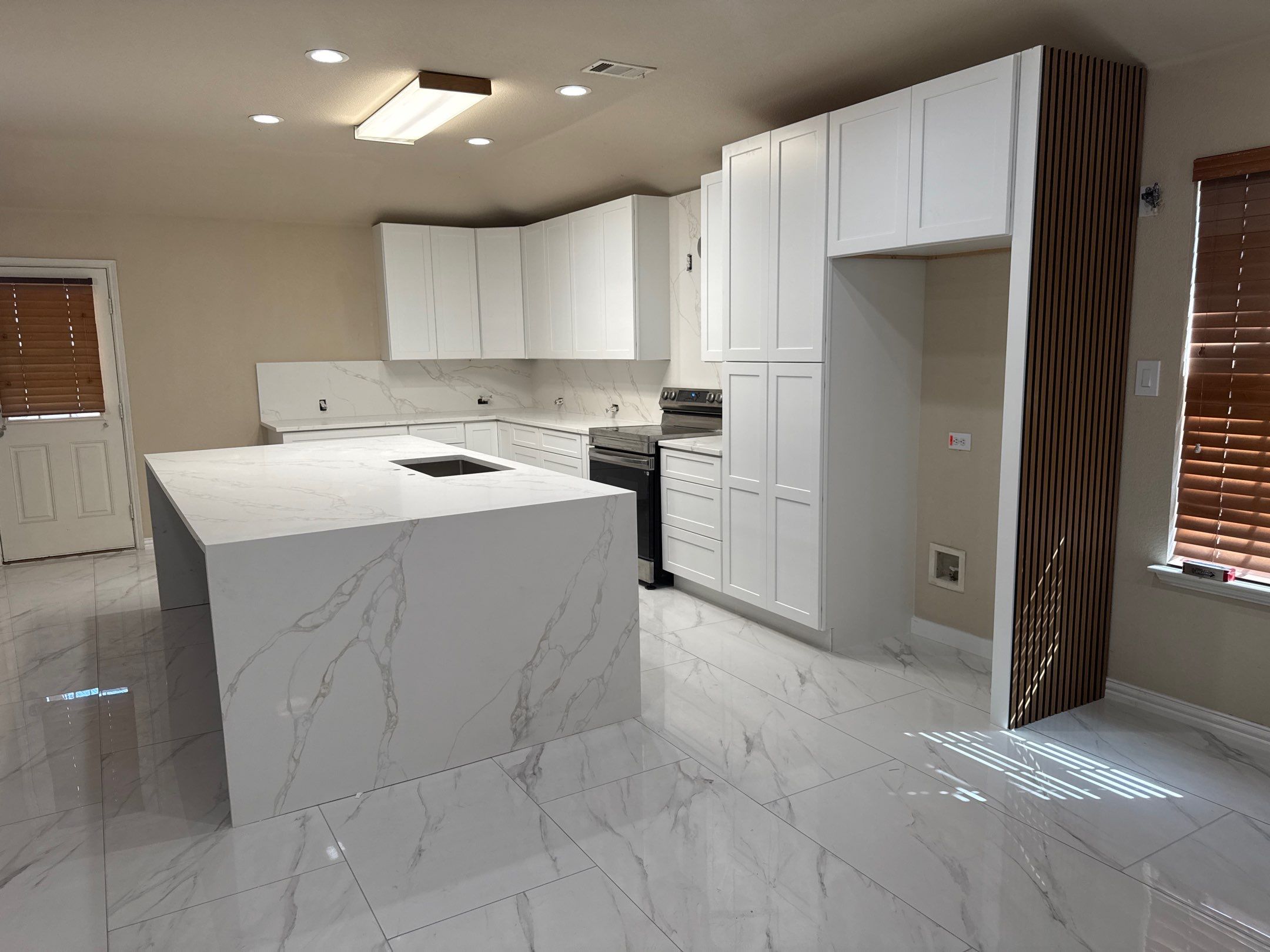 Luxury Focal Point: Full Kitchen Remodel with Double Waterfall Island by Tibi Soli LLC