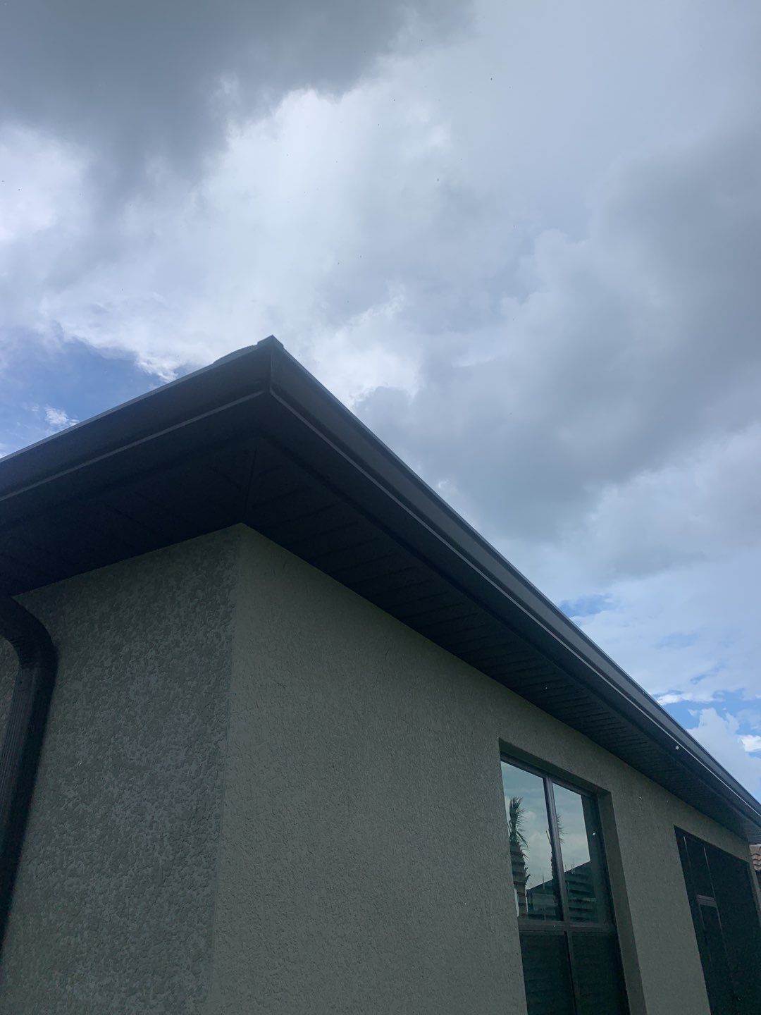 Seamless brown gutter and downspouts installation in Estero, FL  by Gutter Professors