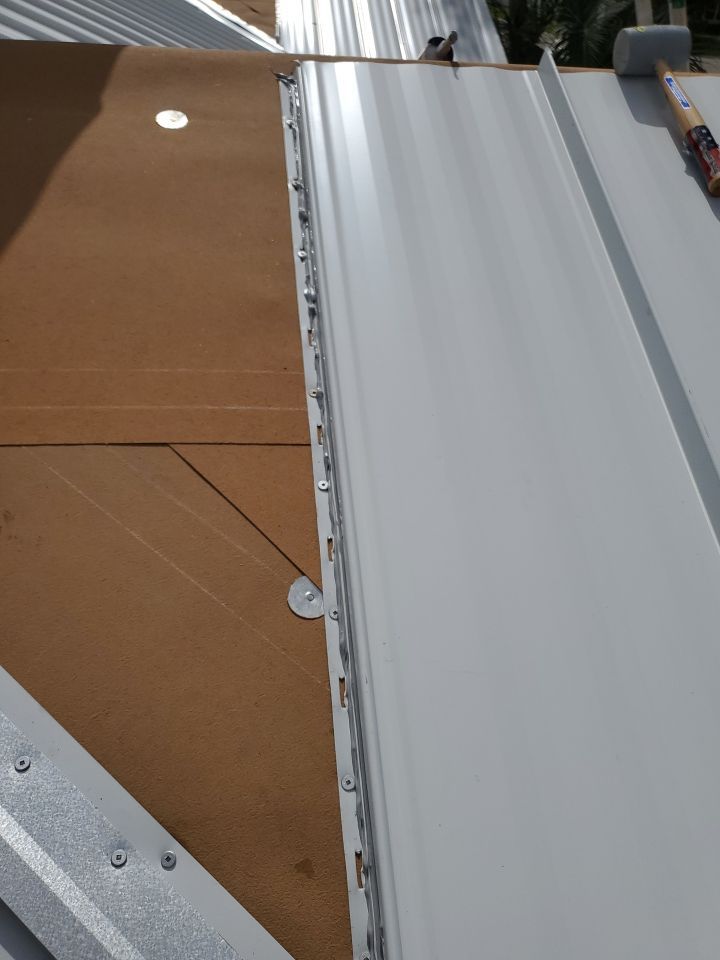 Residential Roofing Installation using 1.5" Nail Strip 24ga Solar White Kynar Coated Standing Seam Metal Panels by Morton Roofing, Inc.