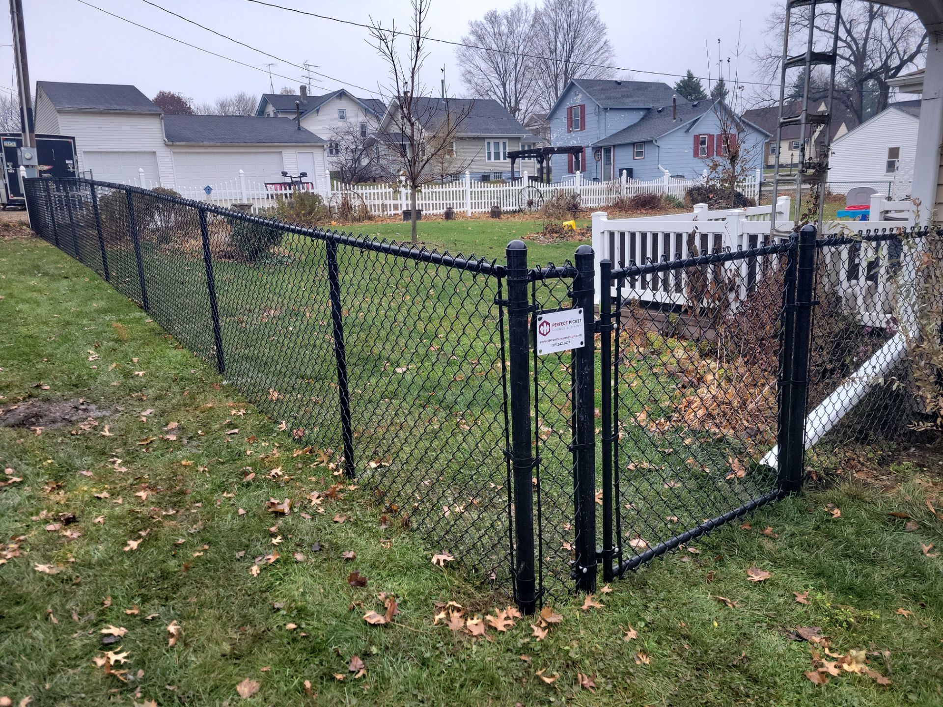 Black Vinyl-Coated Chain Link Fence Installation in Aplington by Perfect Picket Fence and Stain