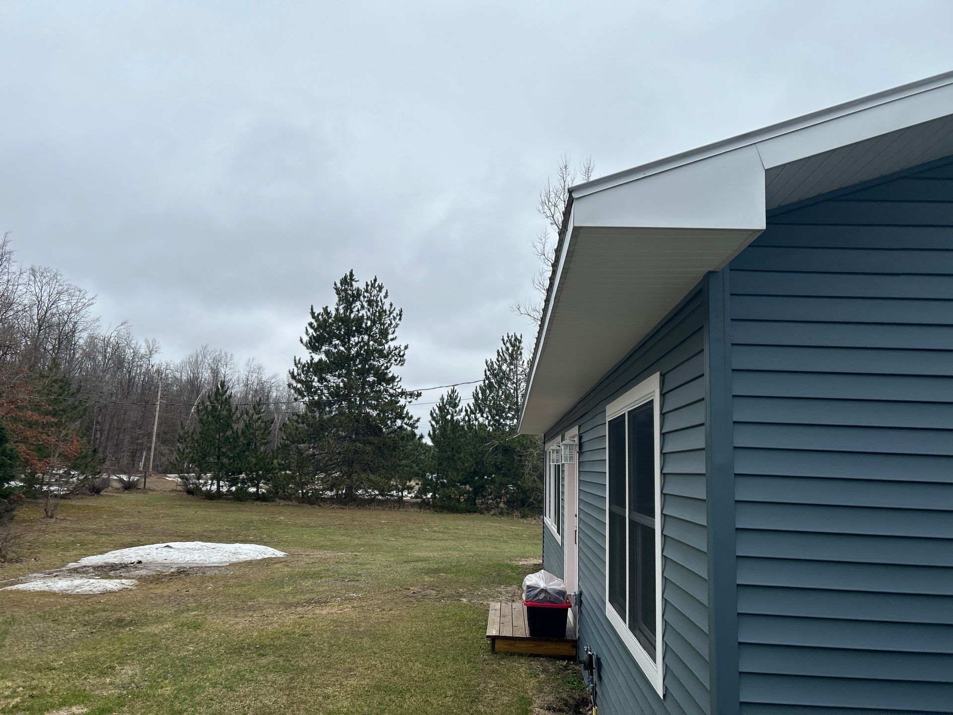 White Gutter and Downspout Installation for Boyne Falls Residential Property by Rainbow Seamless Systems