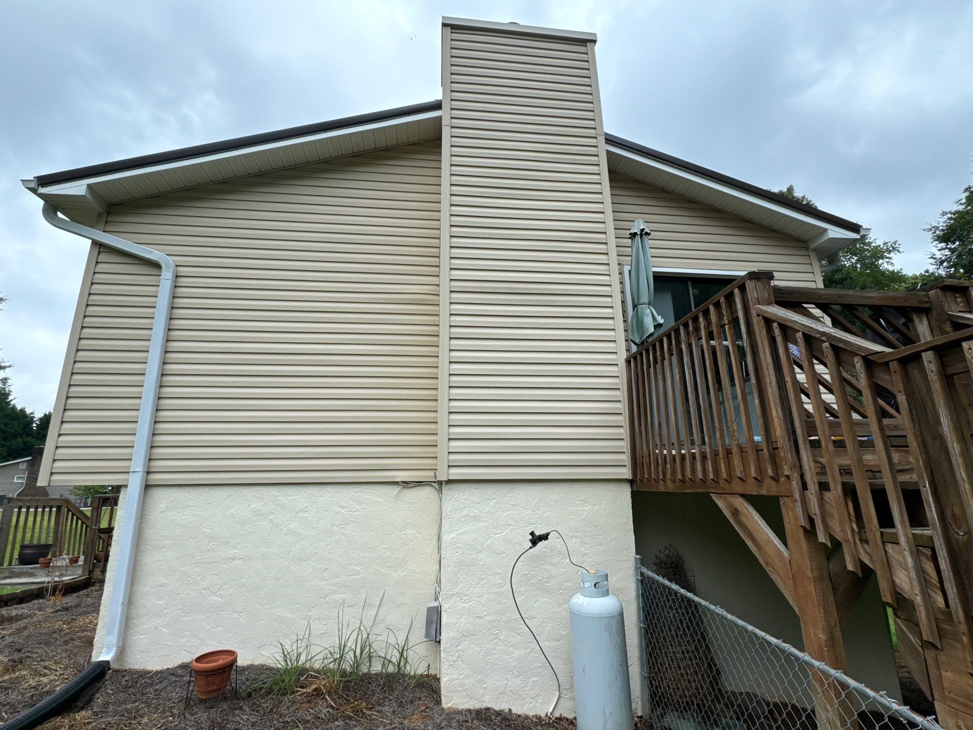 cleaning house siding and wooden deck steps with pressure washing for a thorough exterior cleaning