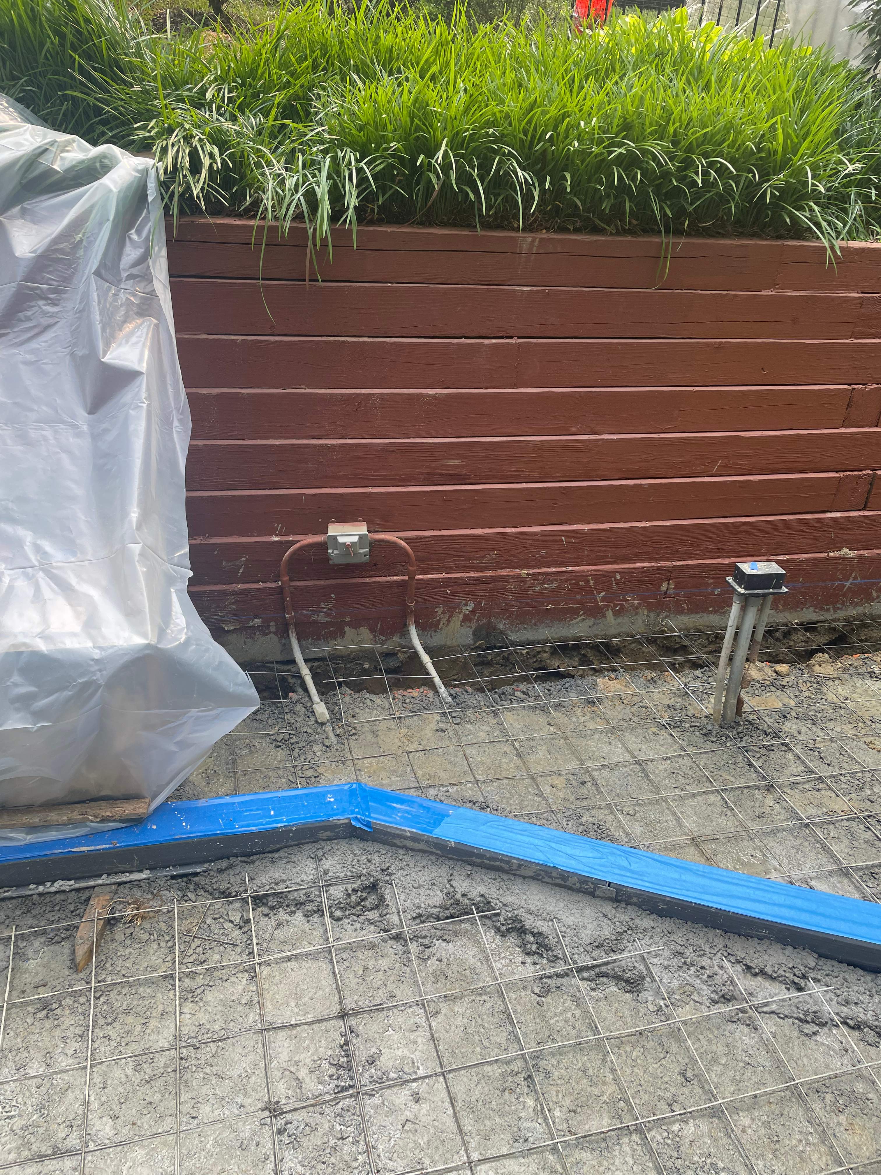 Pool Surround remodel with retaining walls, new waterfall and water slide by Fairfax Contractors, LLC