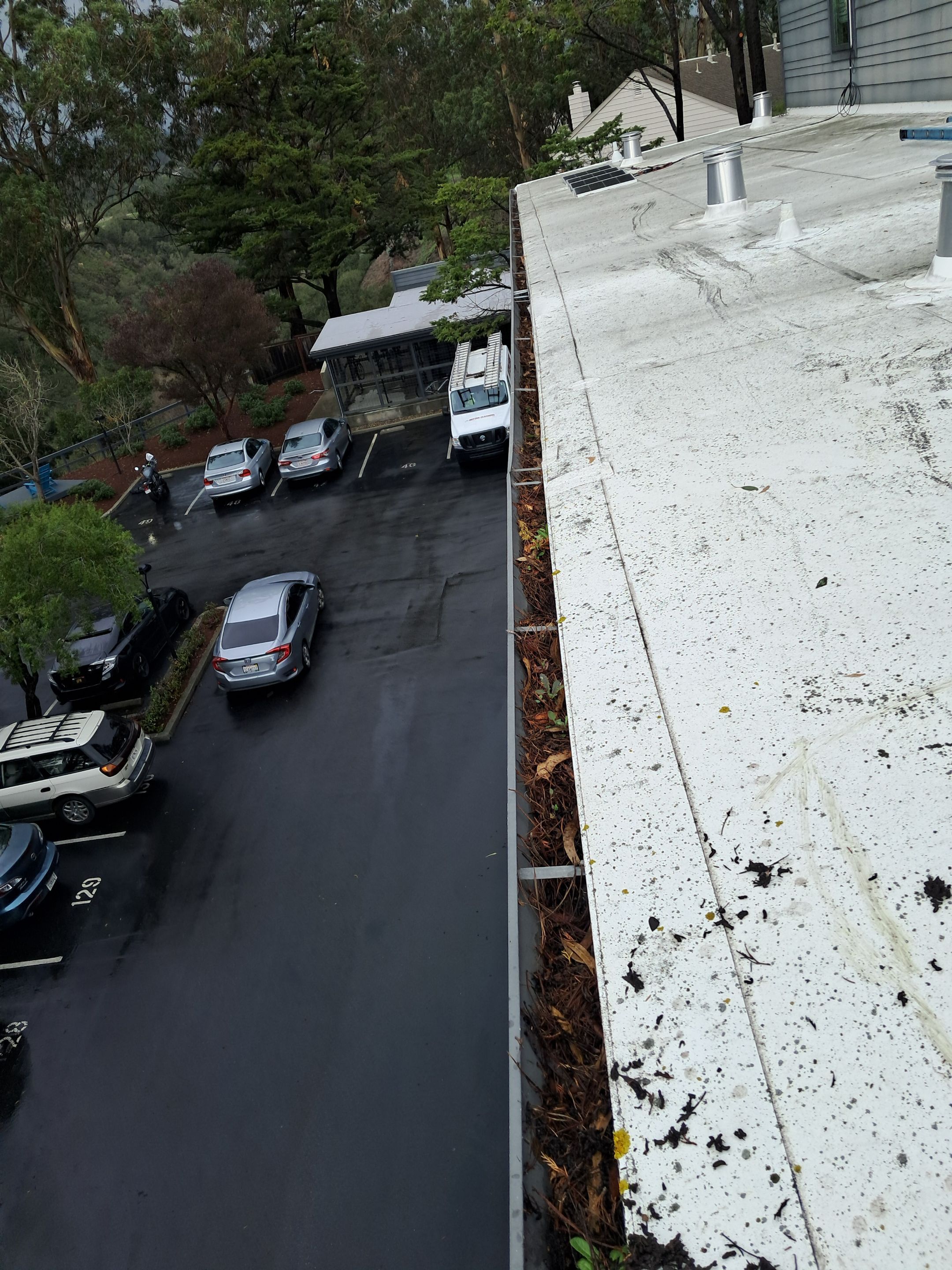 HOA gutter cleaning in Santa Cruz, before photo showing full gutters.