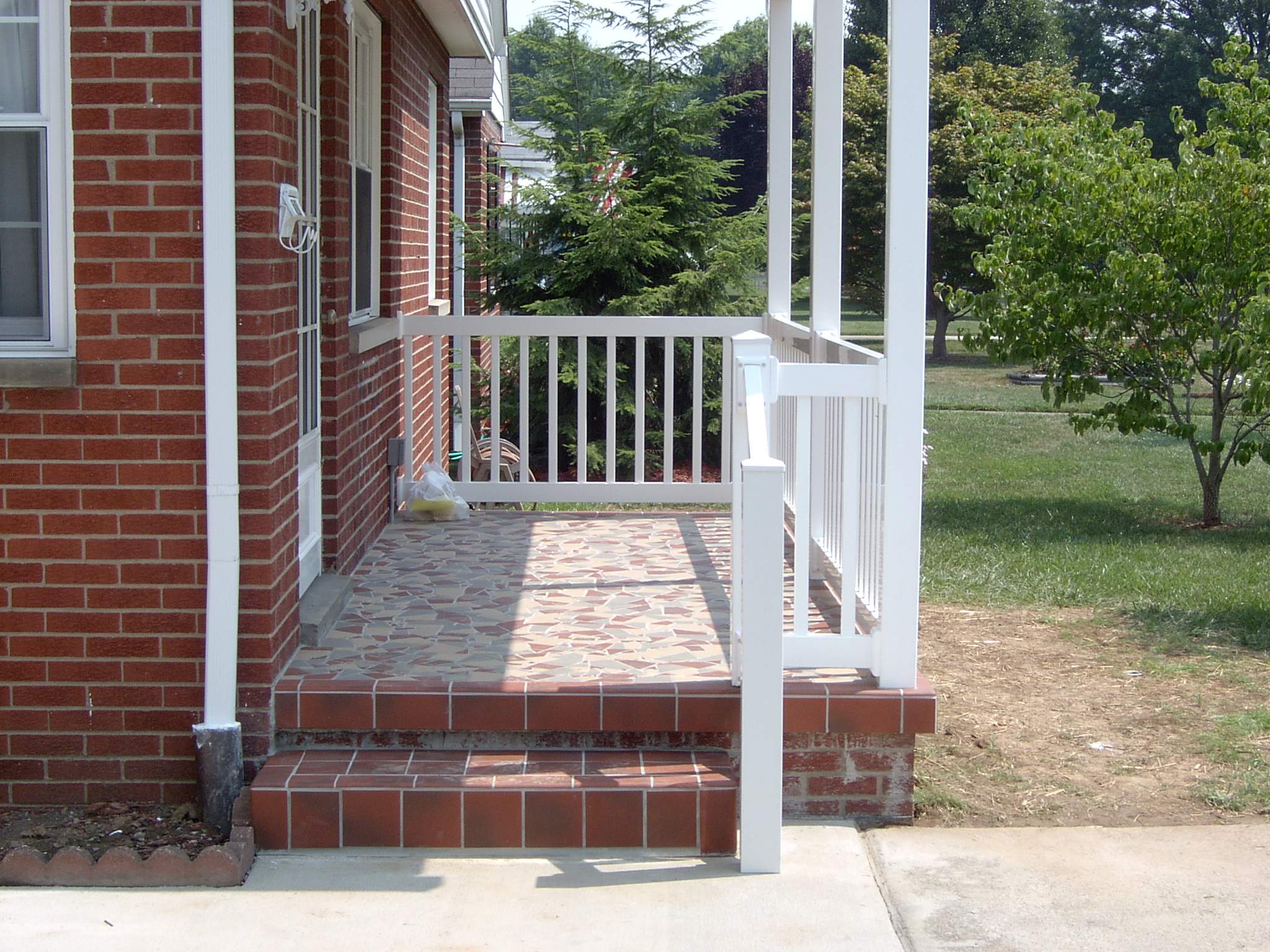 New front porch build, with tile floor and vinyl railing. by Secure Construction Company Inc