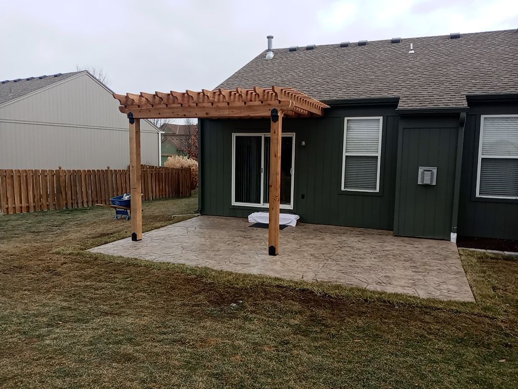 Back Yard Stamped Patio and Pergola by LAND ESCAPES LLC