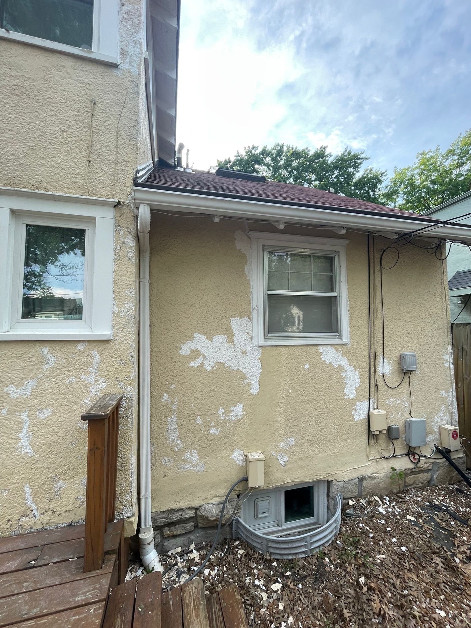 The exterior refresh of this classic Kansas City home is brought to life with timeless neutrals and a bold Sherwin-Williams Naval front door for a striking, welcoming finish. by Cougar Painting