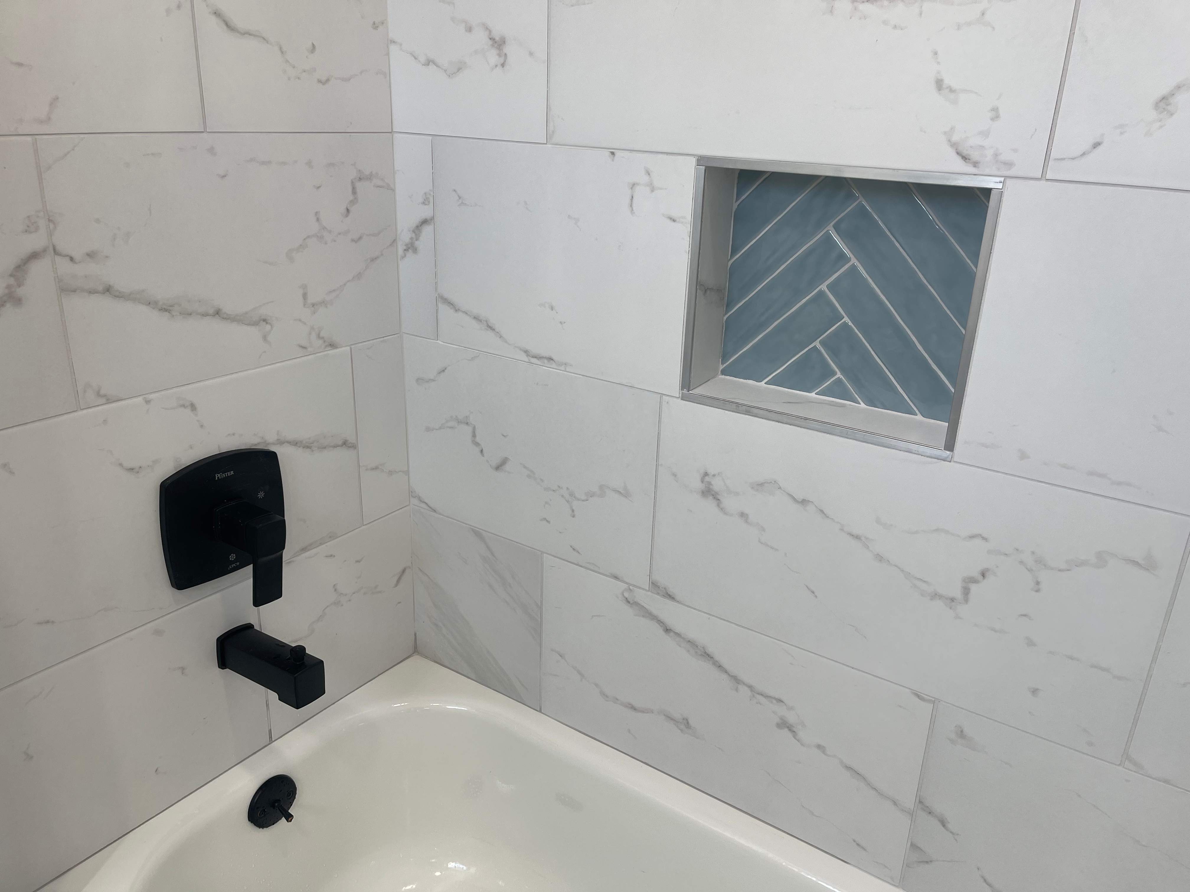 Complete Bathroom Remodel Featuring Marble Tile and Teal Herringbone Niche by Mena stone surfaces