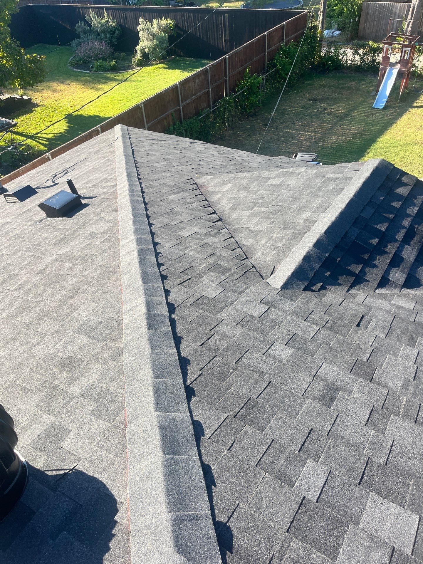 White brick/light gray shutters with IKO Granite Black  by Tejas Roofworks + Restoration