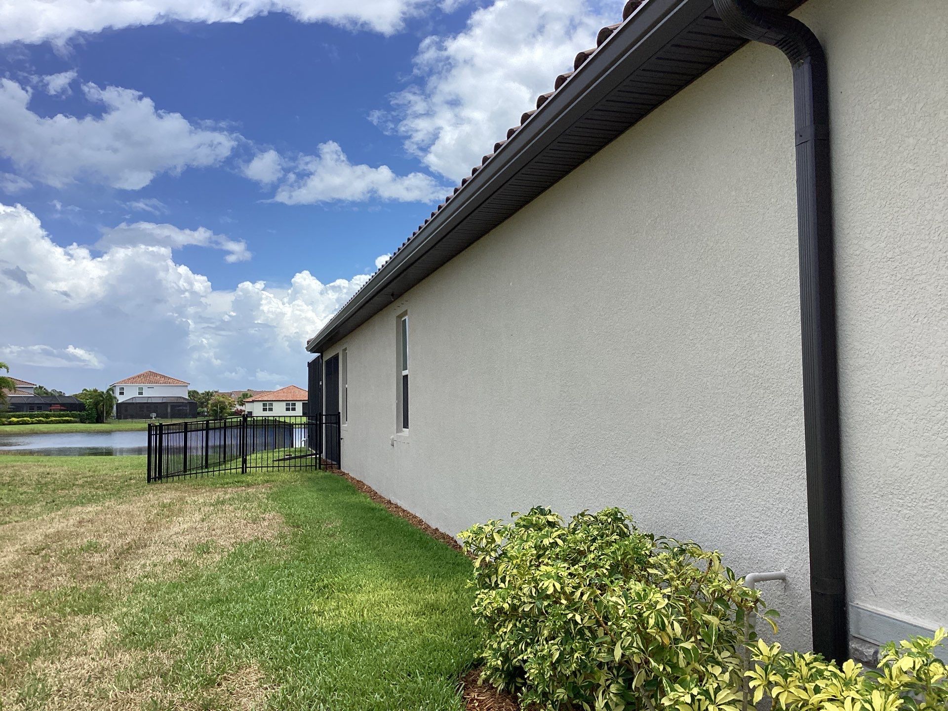 Musket brown seamless gutters with splash guards, new downspouts, and extensions in Bradenton, FL by Gutter Professors
