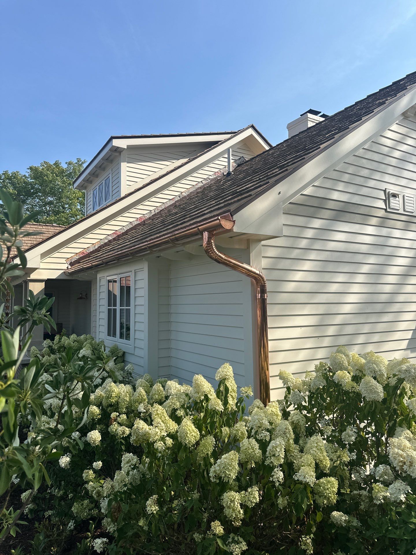 Custom Copper Gutter System and Accent Roofing in East Jordan by Rainbow Seamless Systems