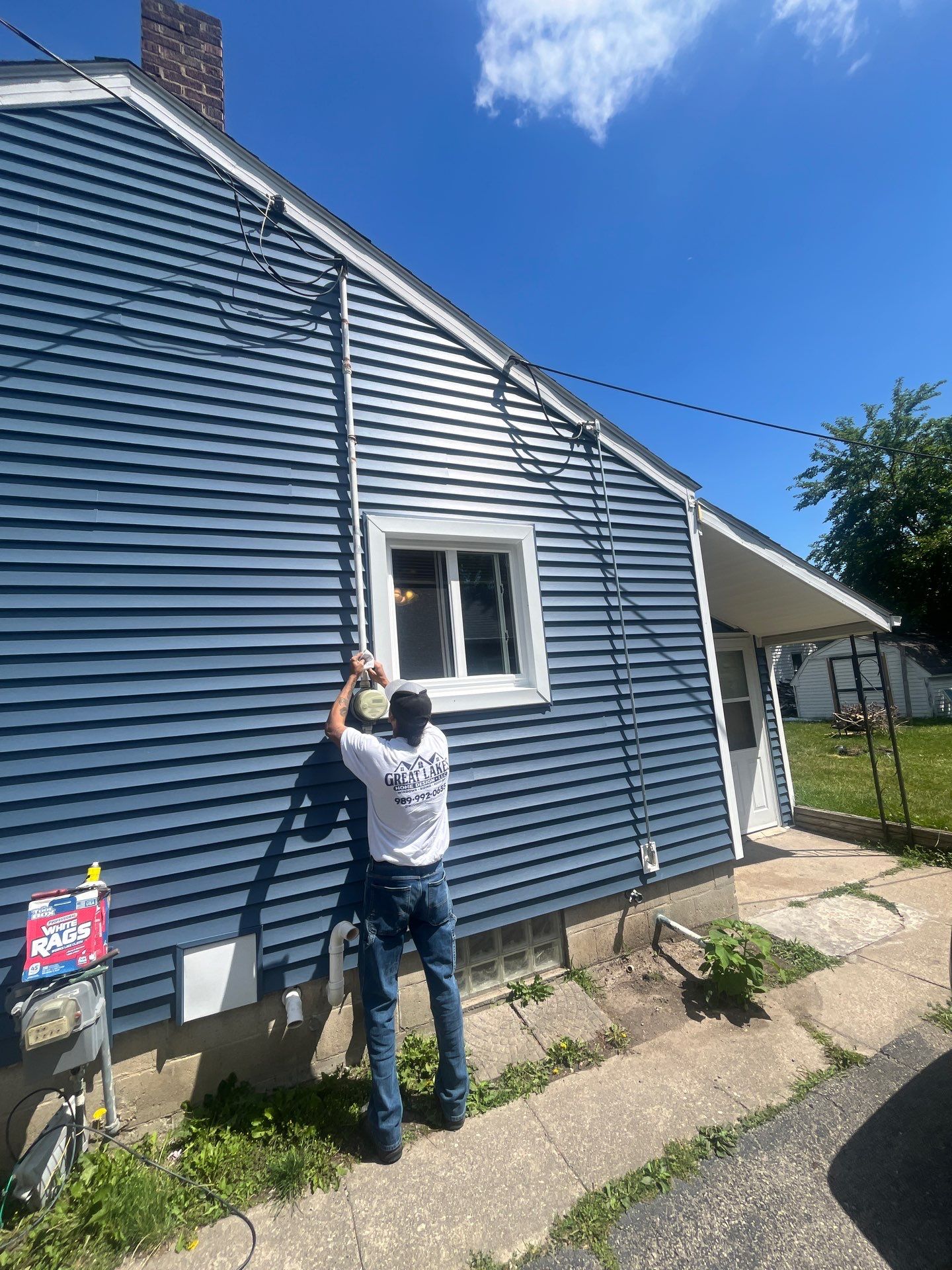 Blue Vinyl Siding and Versetta Stone Exterior Remodel in Bay City by Great Lakes Home Design LLC
