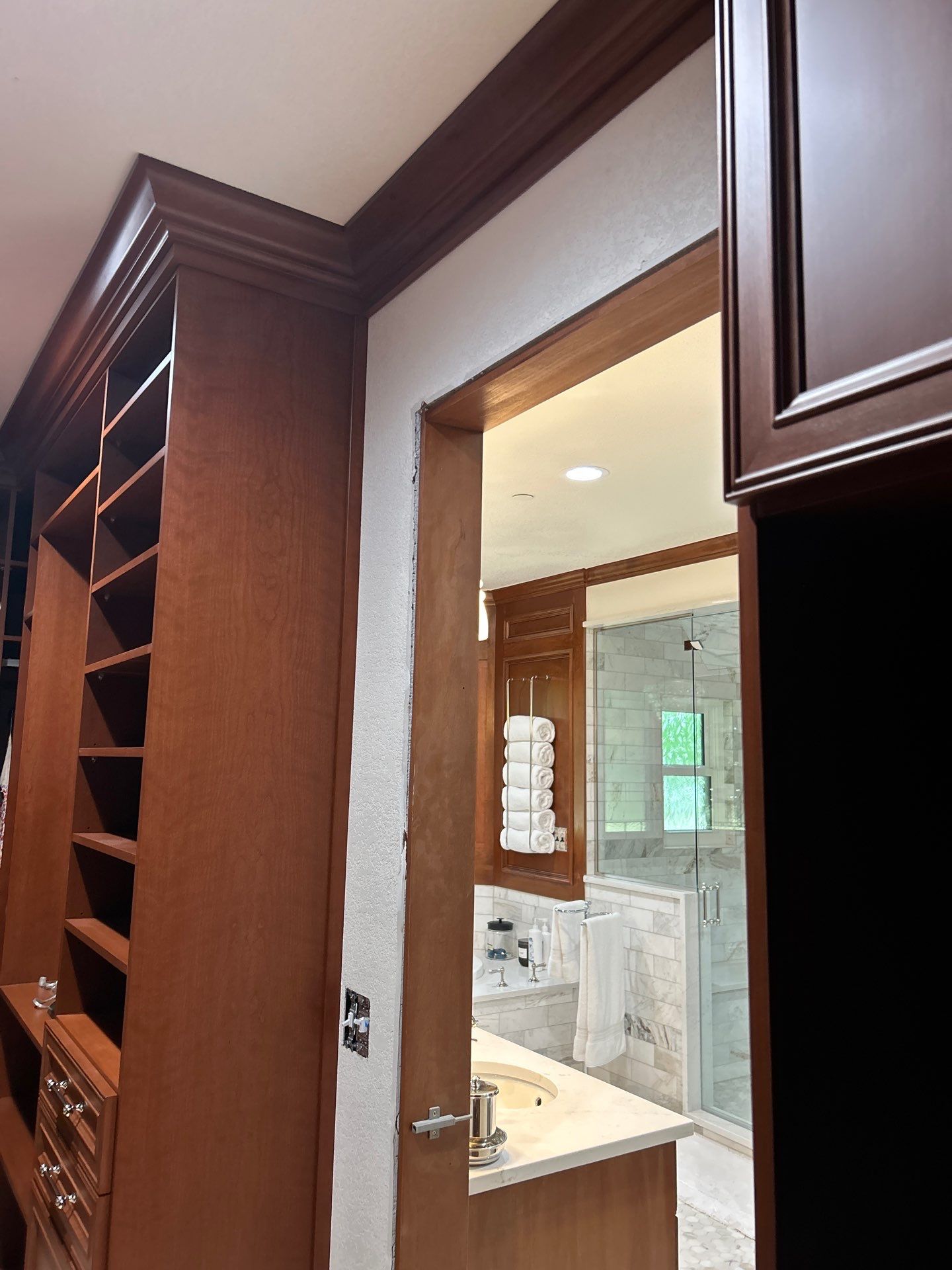 Stained Cherry Wood Primary Closet by Concept 32, Inc.