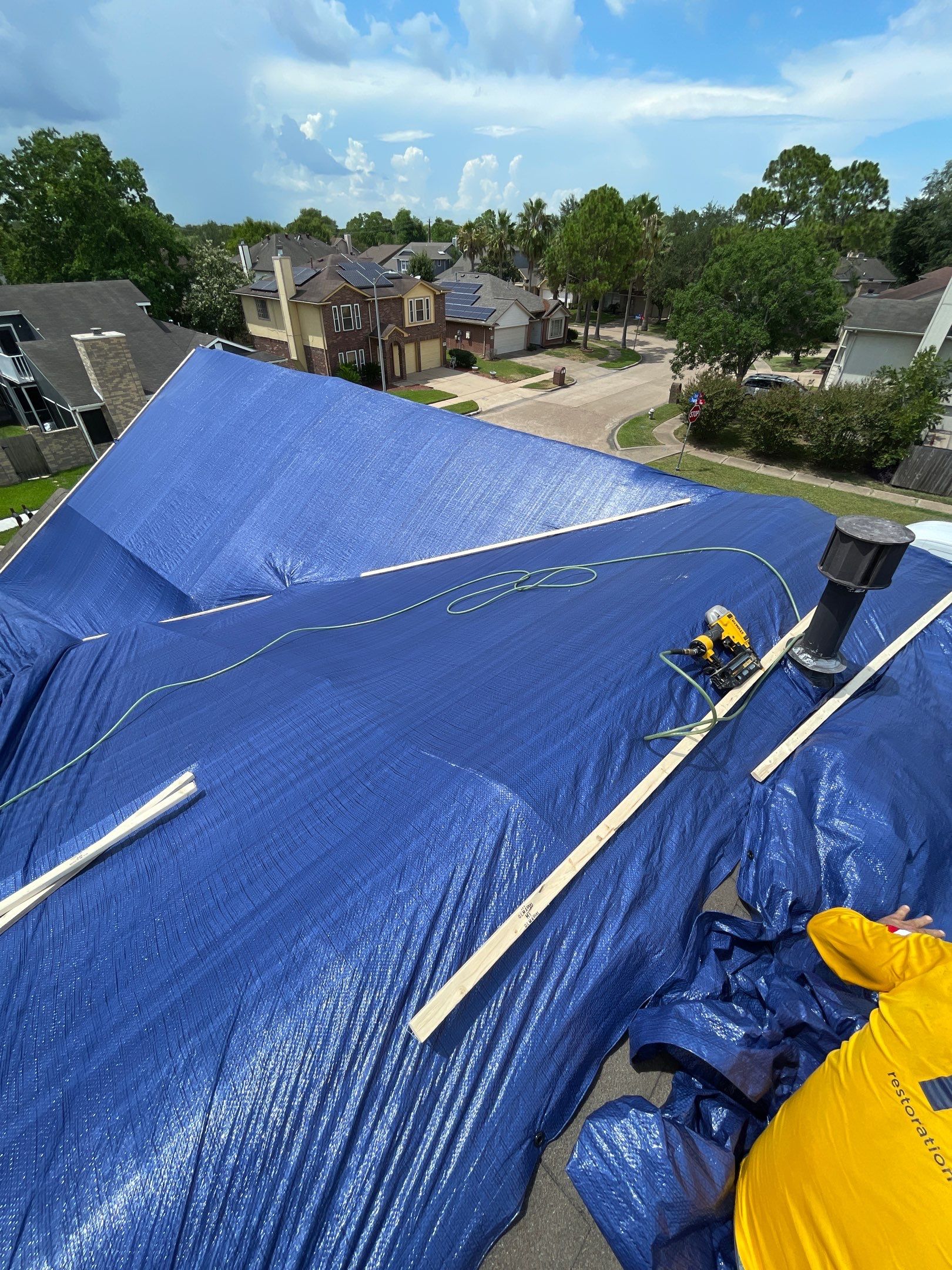 Placement of tarps on the roof. using TARP BLUE by V General Contractors 