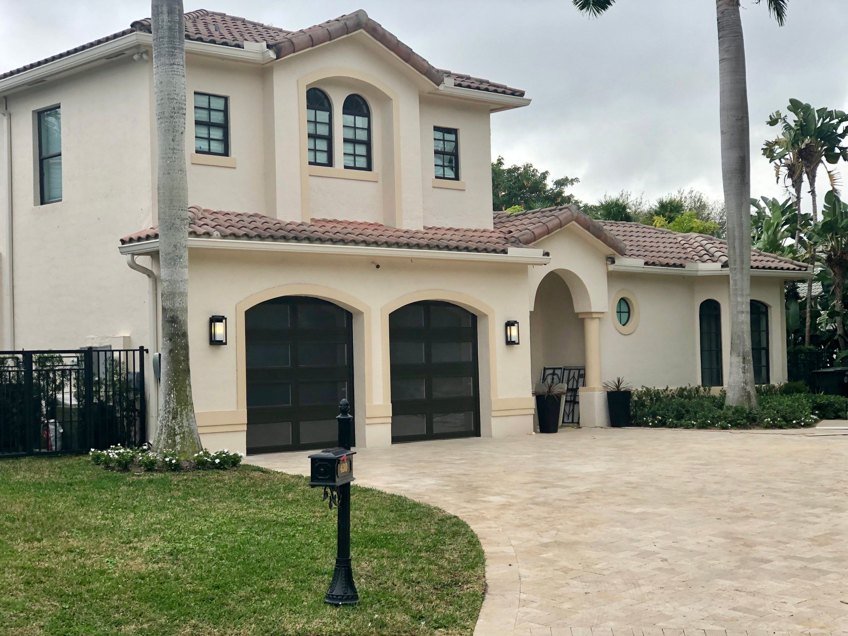 Modern Bronze Garage Door Installation With Frosted Glass in Boca Raton by The Door Doctor of South Florida, Inc.