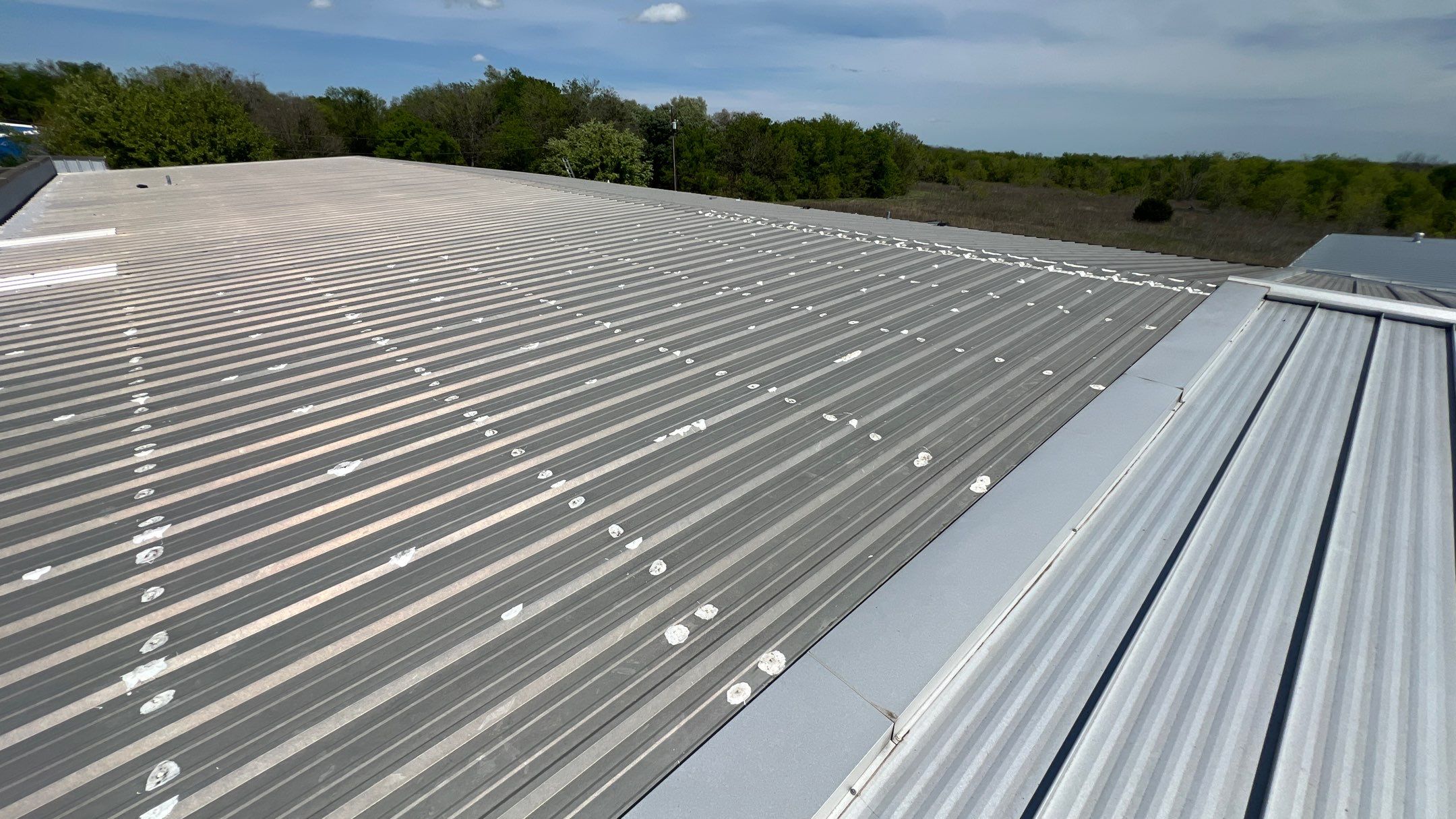 Commercial Roofing Installation using TRP #924 Eterna-Sil Premium Silicone Roof Coating by Harvey Roofing & Construction