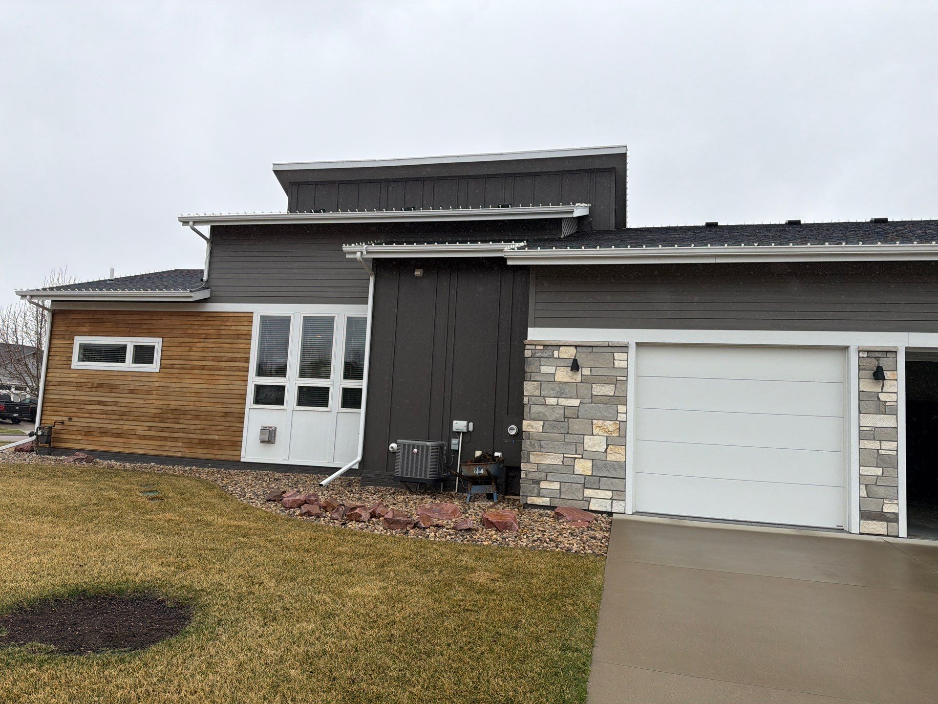 Modern Exterior Transformation Featuring Dark Board and Batten Siding in Sioux Falls by Select Painting, Coatings & Garage Cabinets