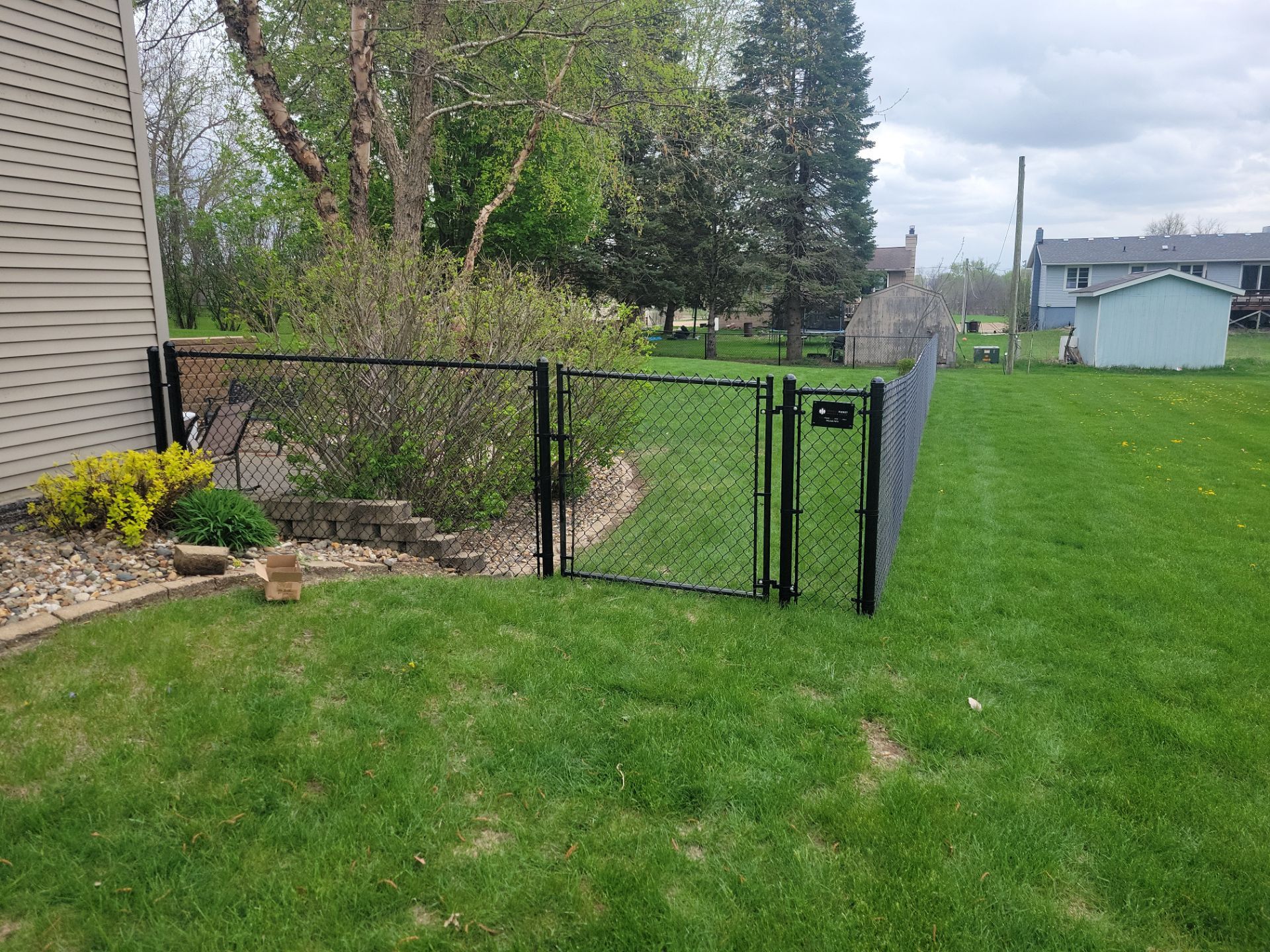 Residential Black Vinyl-Coated Chain Link Perimeter Fence in Garwin by Perfect Picket Fence and Stain
