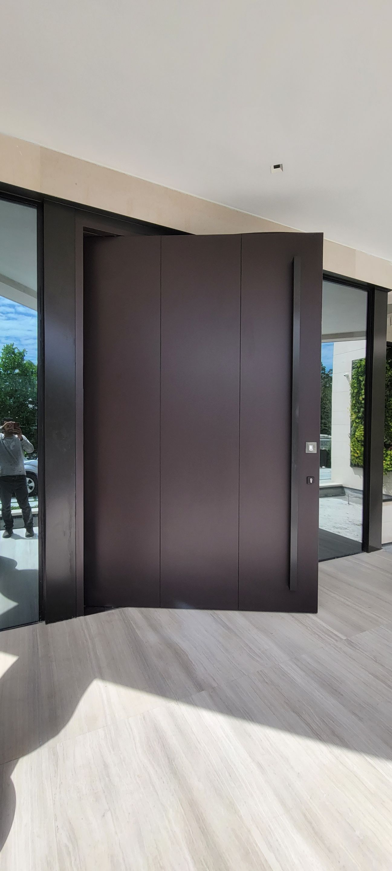 Custom Material Pivot Door installation by Impact Precious Wood Inc.