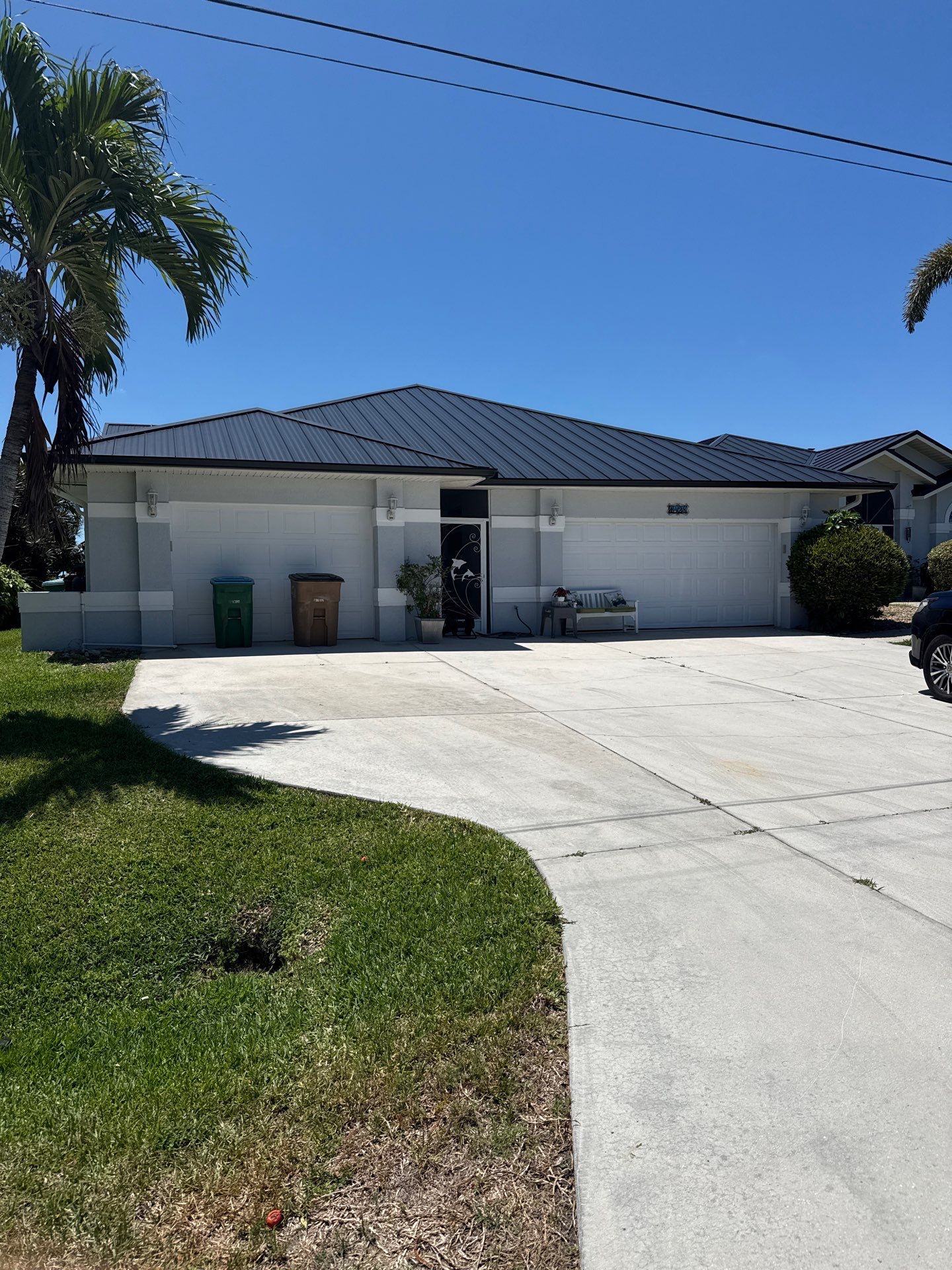 Black Seamless Gutters and White Downspouts in Cape Coral FL by Gutter Professors