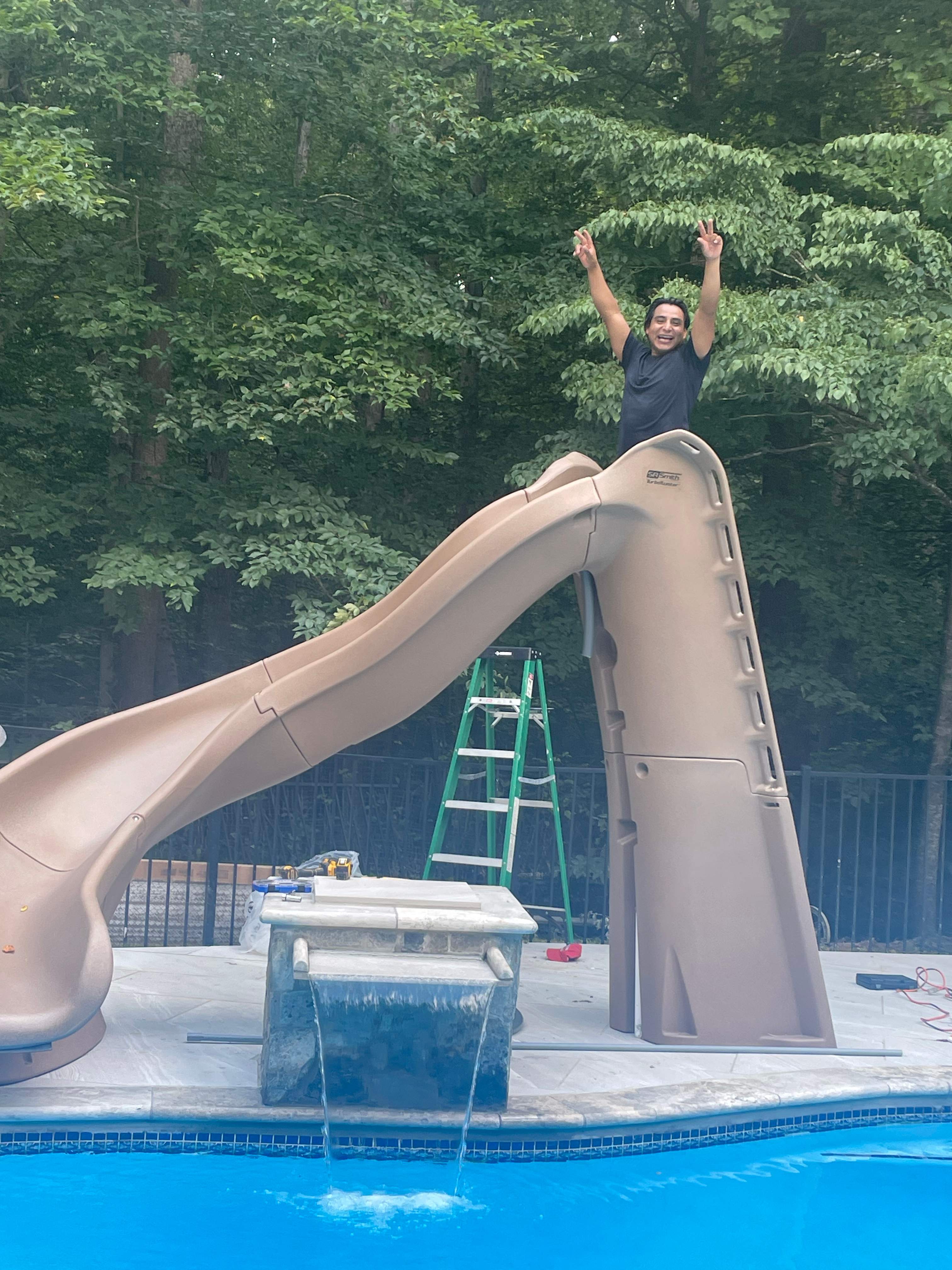 Pool Surround remodel with retaining walls, new waterfall and water slide by Fairfax Contractors, LLC