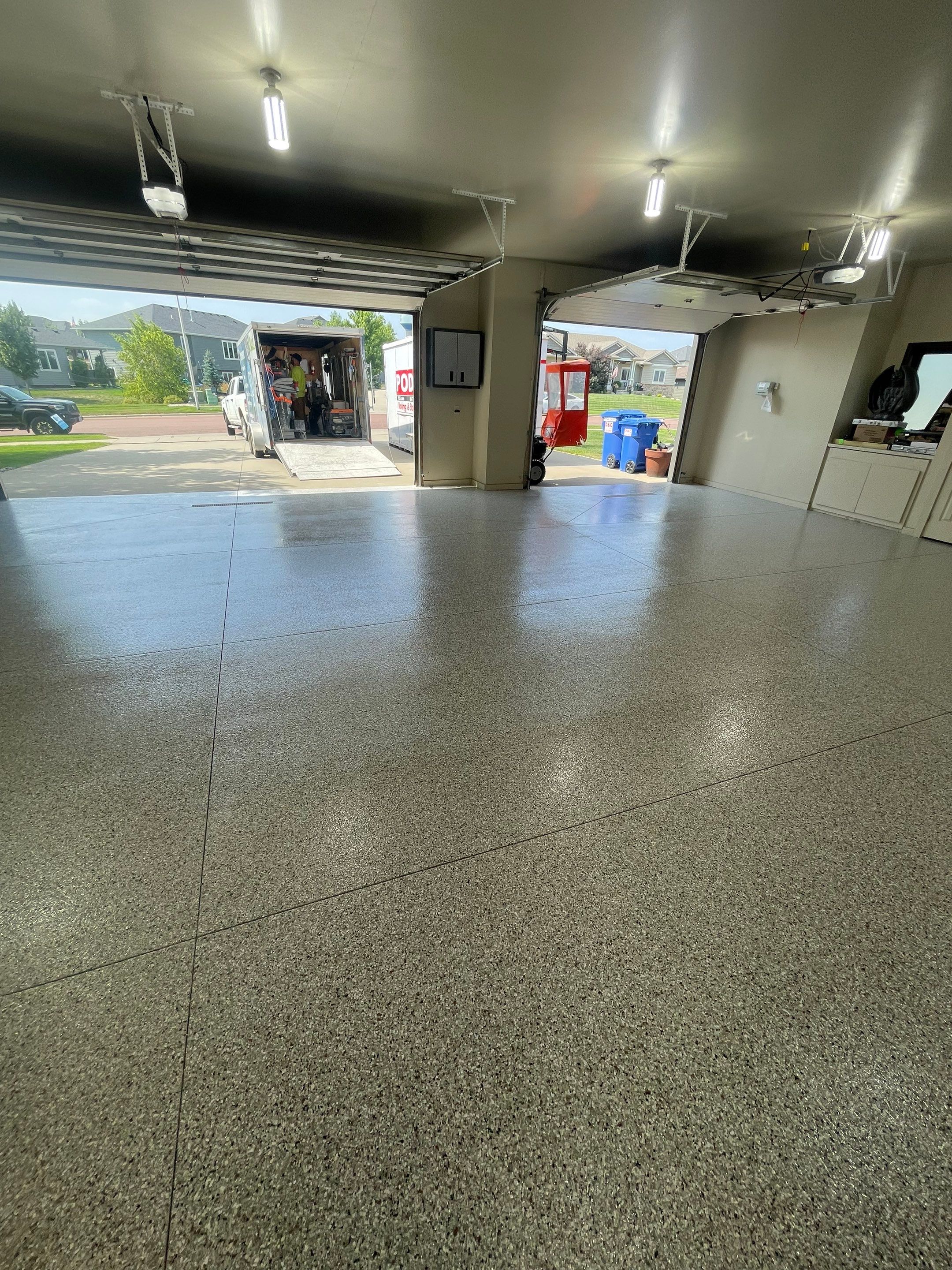 Coyote Flake Garage Floor Coating in Sioux Falls with Trench Drain by Select Painting, Coatings & Garage Cabinets