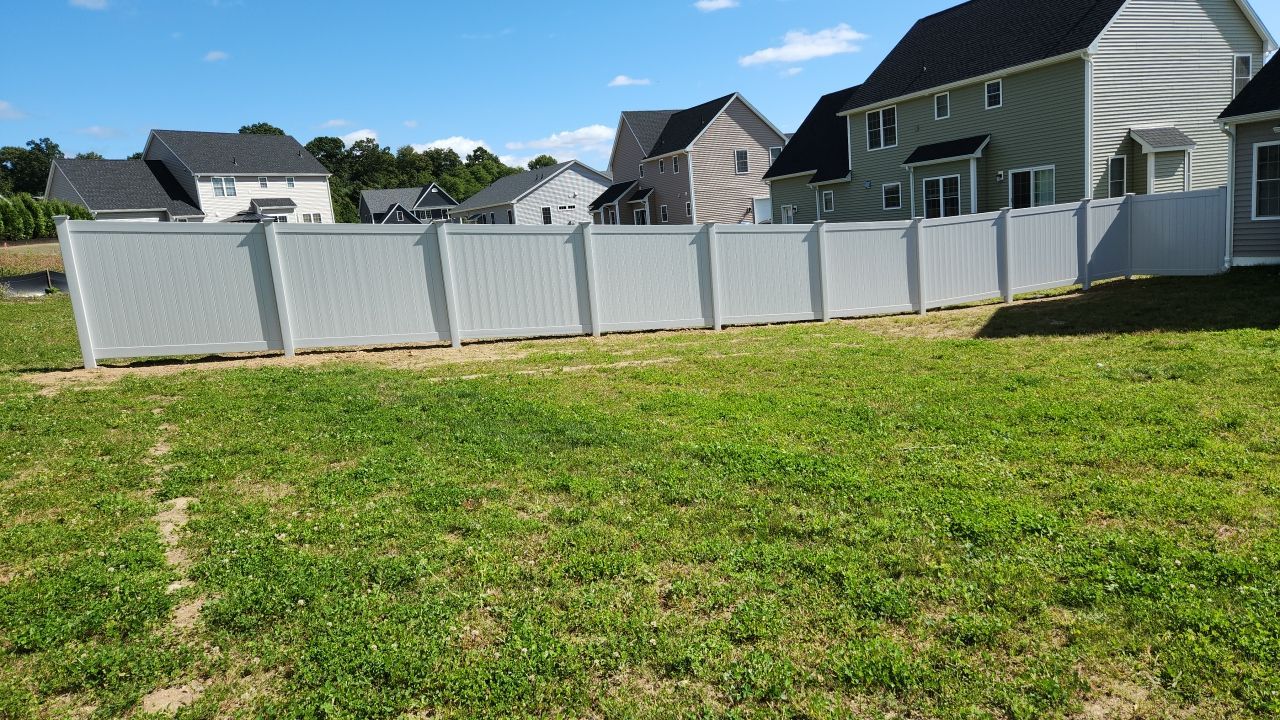 New Vinyl privacy fence with matching gates in Classic Gray by DiGiorgi Roofing and Siding Inc