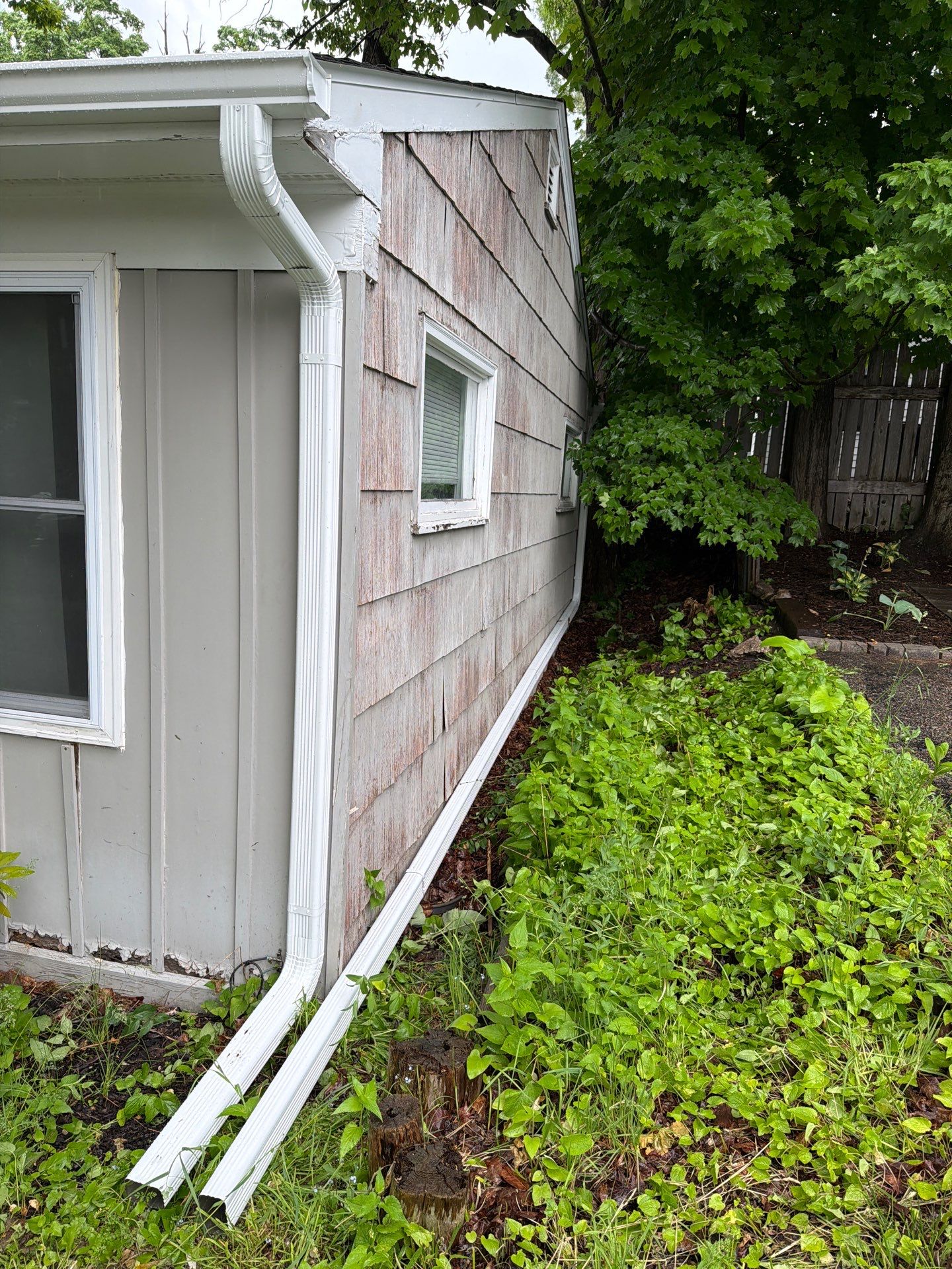 White Gutter and Downspout System Installation in Petoskey by Rainbow Seamless Systems
