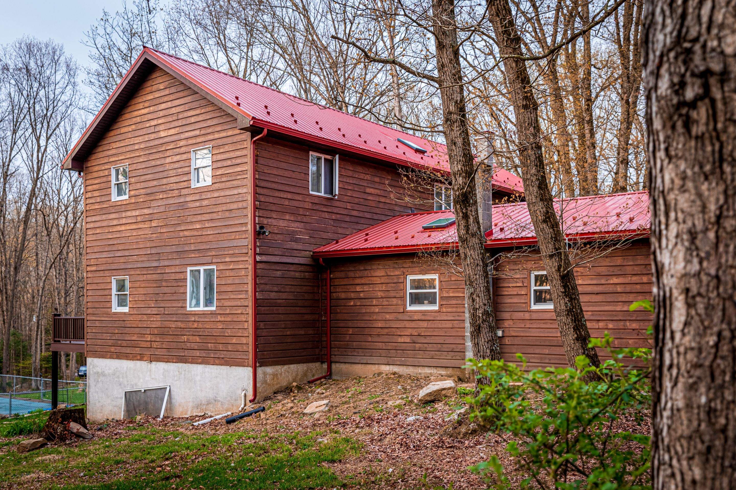 Metal Roof-barn red and new deck by Esh Builders