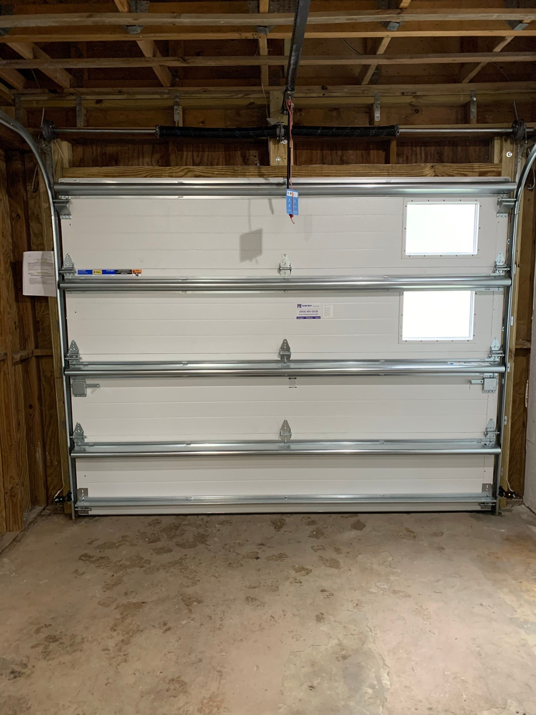 Sectional Garage Door Installation with Wood-Grain Finish in Sunrise - Clopay Modern Steel by The Door Doctor of South Florida, Inc.