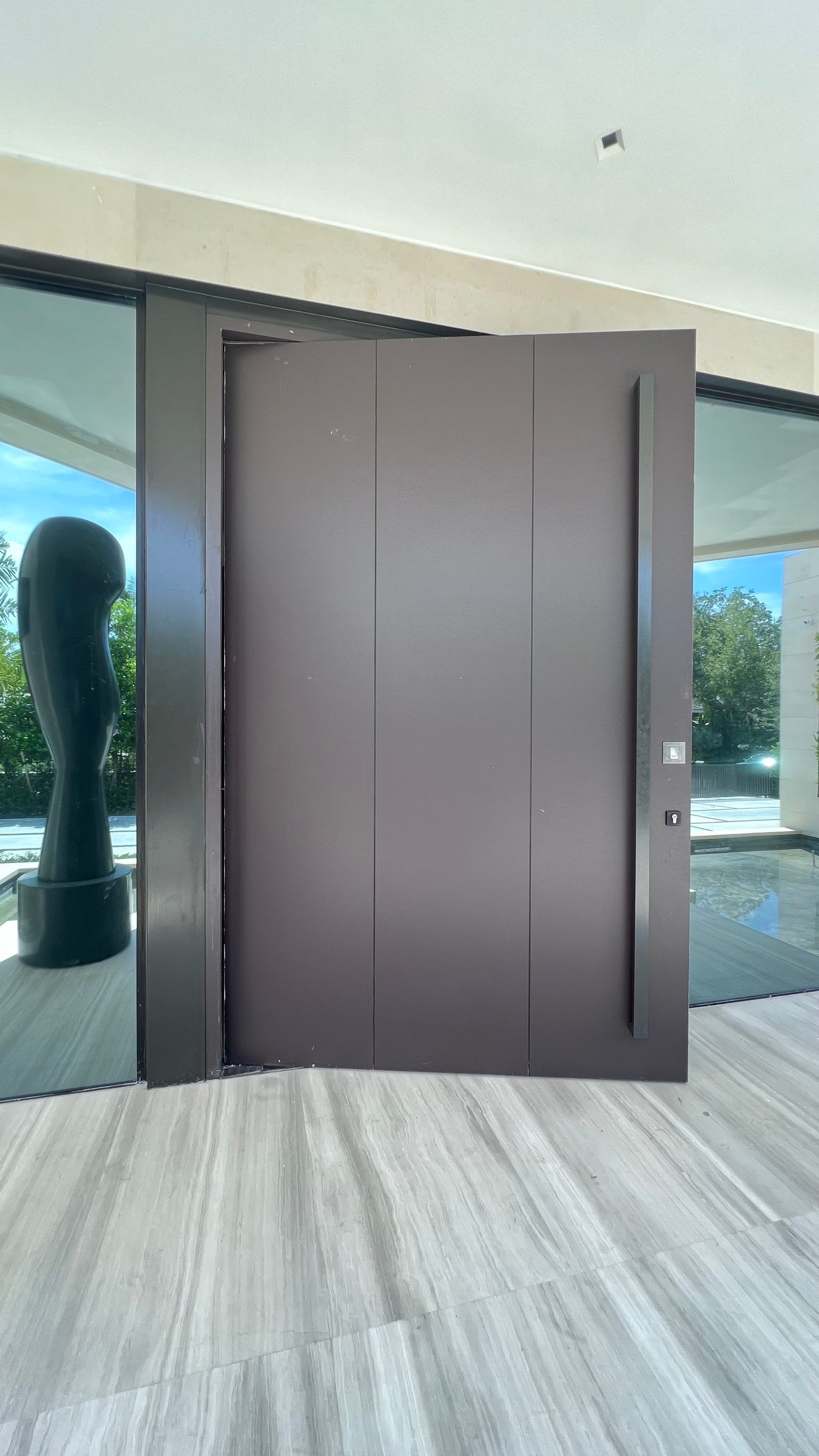 Custom Material Pivot Door installation by Impact Precious Wood Inc.