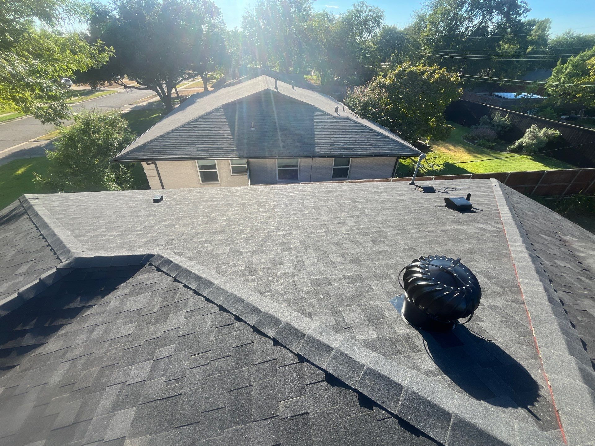 White brick/light gray shutters with IKO Granite Black  by Tejas Roofworks + Restoration