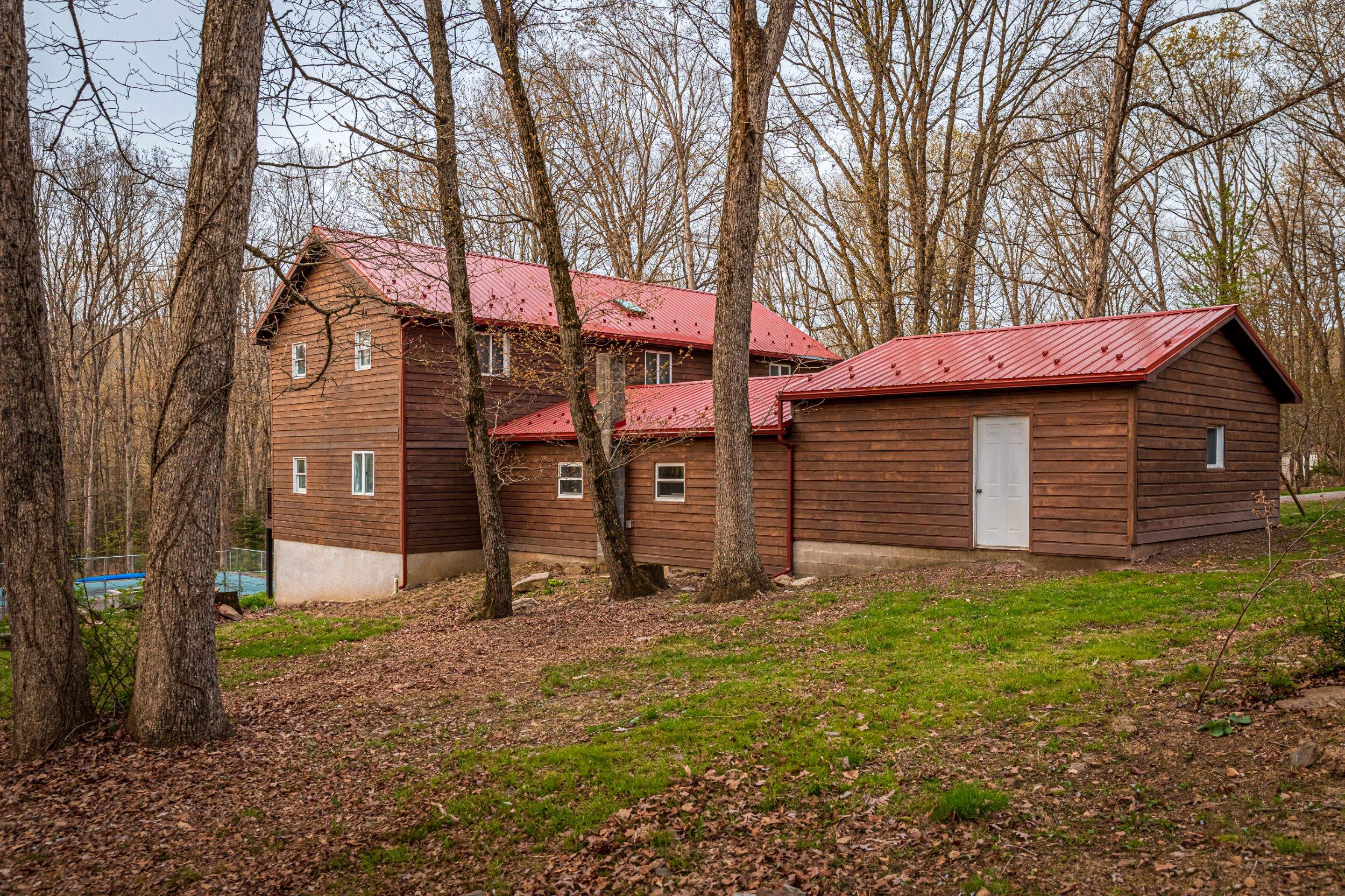 Metal Roof-barn red and new deck by Esh Builders