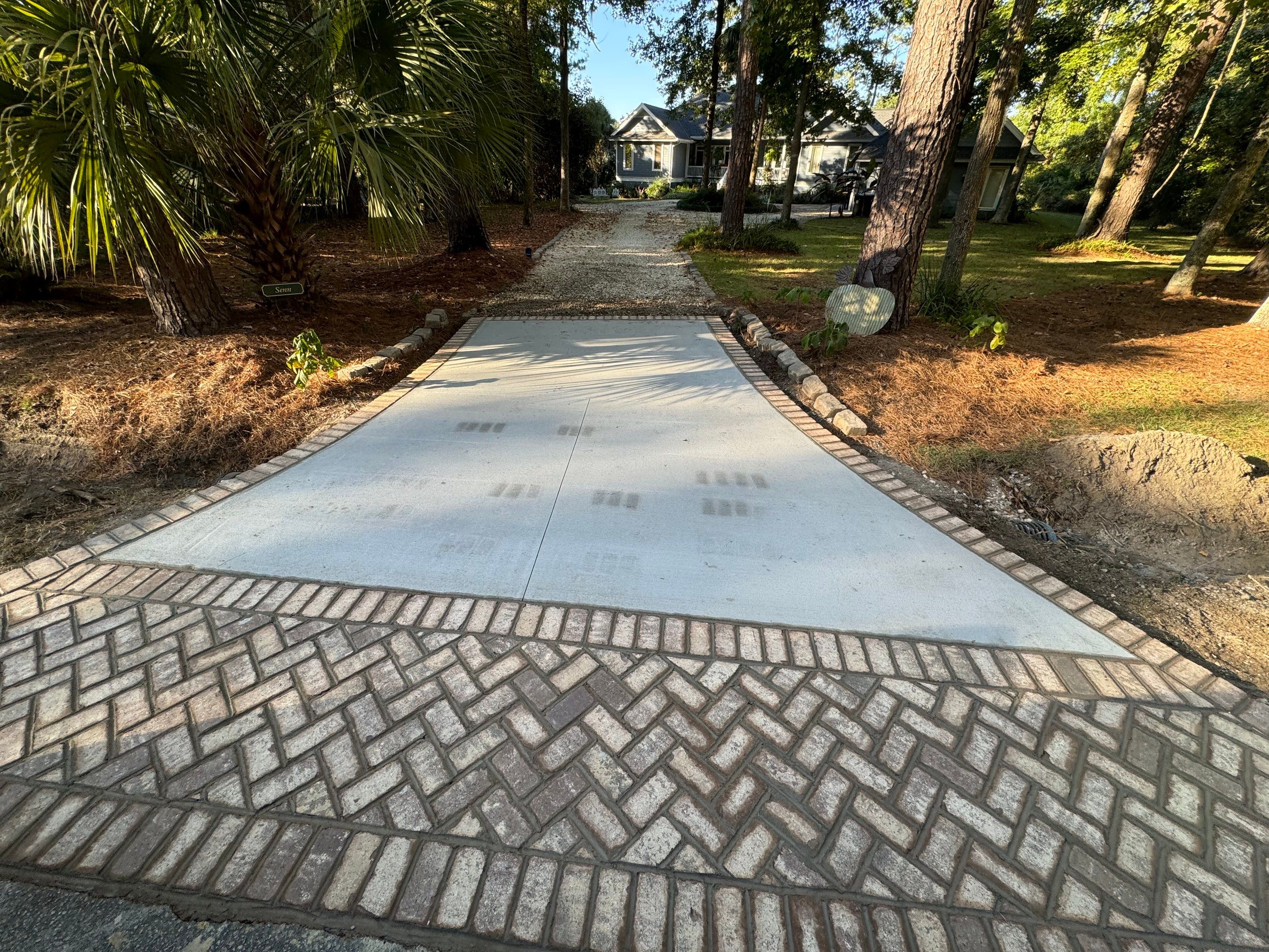 Concrete Driveway and Patio Installation With Decorative Brick Borders