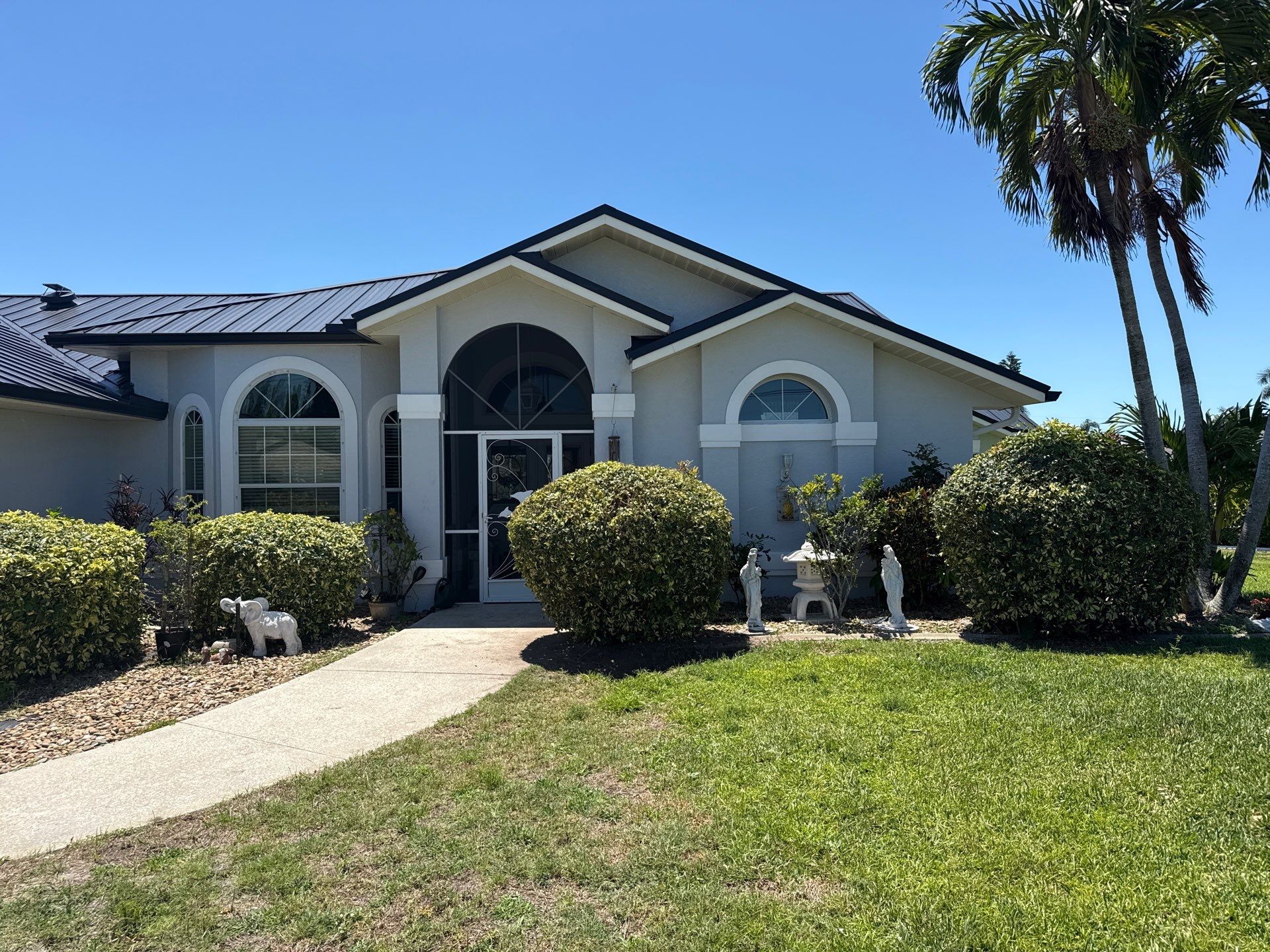 Black Seamless Gutters and White Downspouts in Cape Coral FL by Gutter Professors