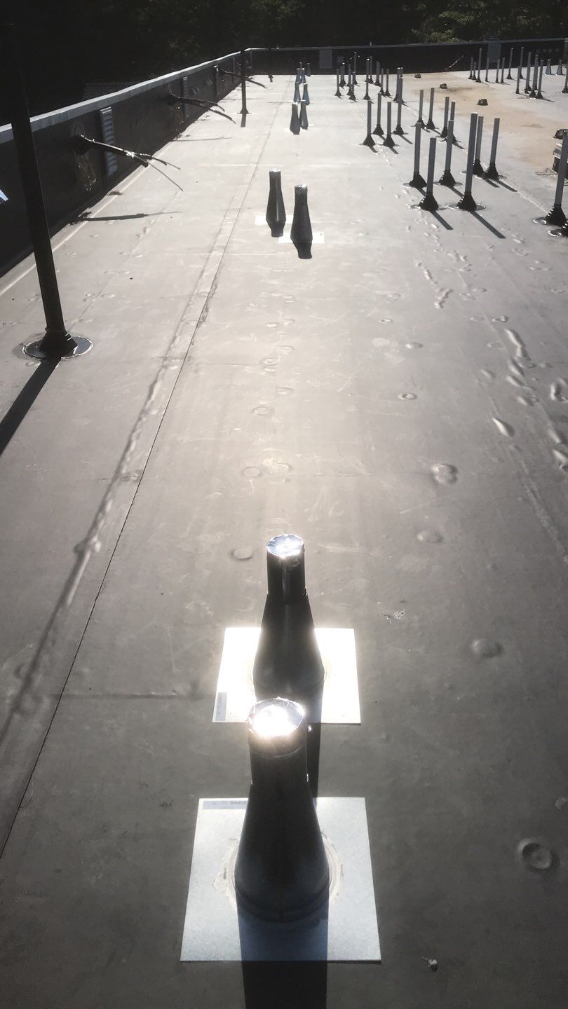 Commercial Roofing Installation using EPDM with white gutters by A Plus Exterior