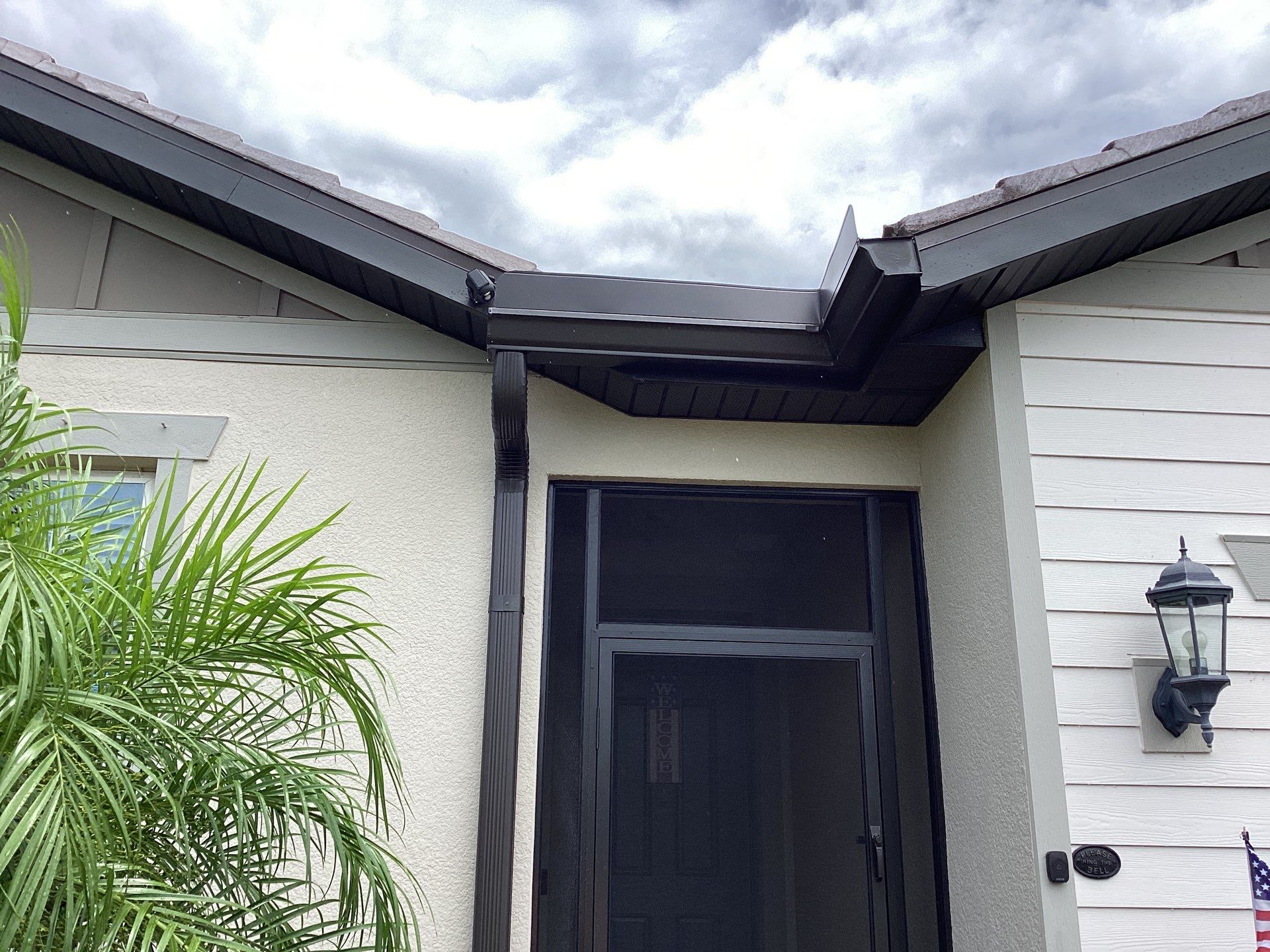 Musket brown seamless gutters with splash guards, new downspouts, and extensions in Bradenton, FL by Gutter Professors